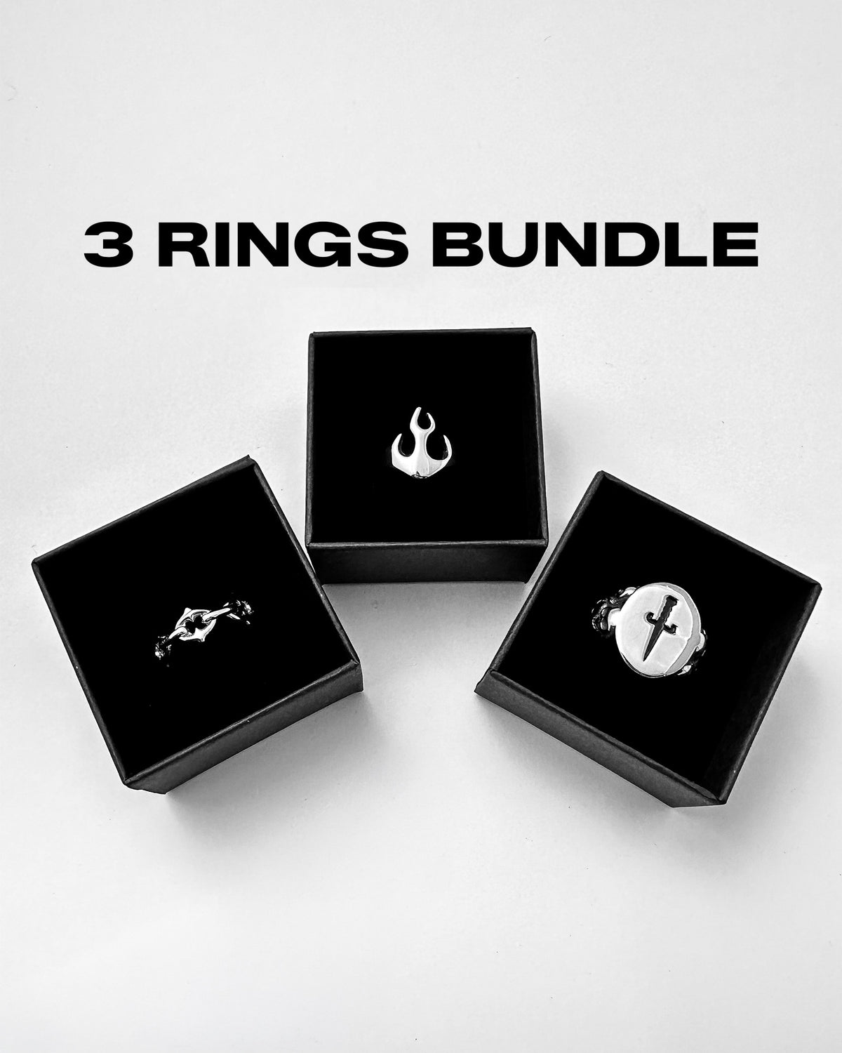 Three rings, each presented in a black box—featuring a flame, a bat, and a cross design—are arranged beneath the text “3 Rings Bundle” by Statement Collective on a white background.