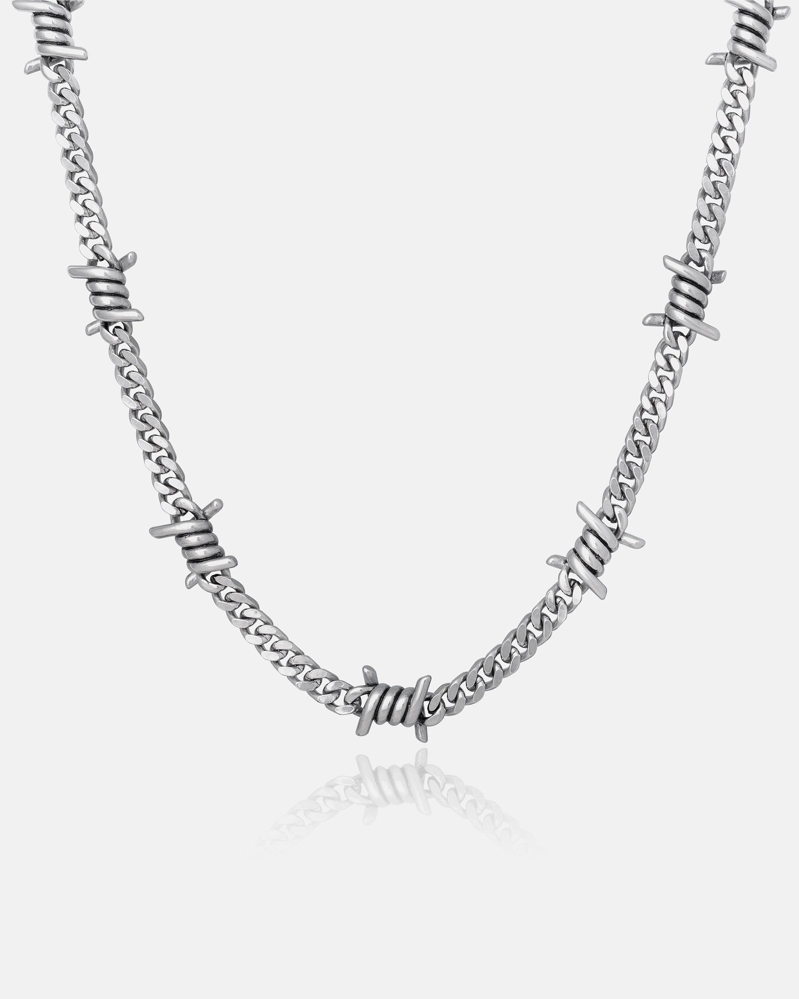 The 6mm Barbed Wire Cuban Chain features silver barbed wire details evenly spaced along the chain, creating a striking statement piece, shown against a plain white background.