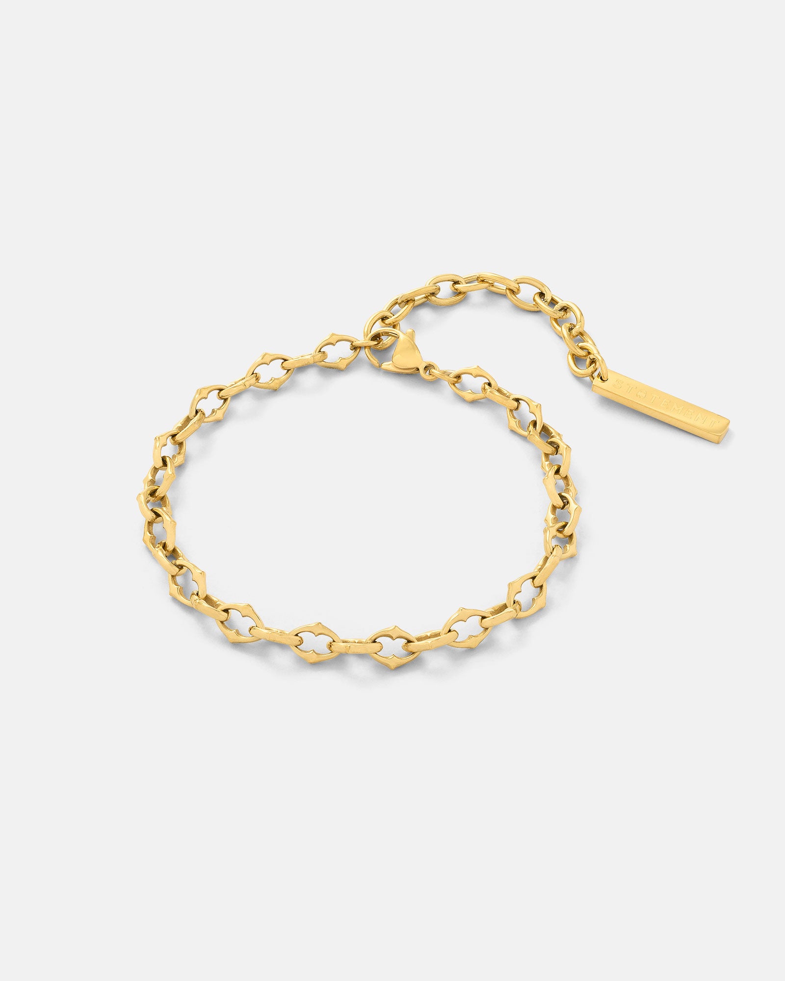 Gold 6mm spiked chain link bracelet by statement collective on grey background