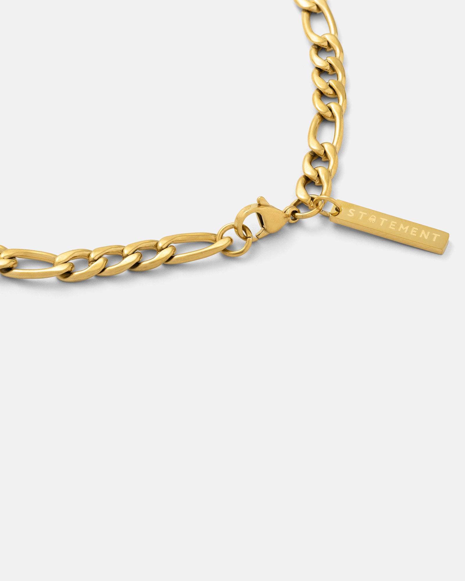gold figaro necklace with tag by STATEMENT