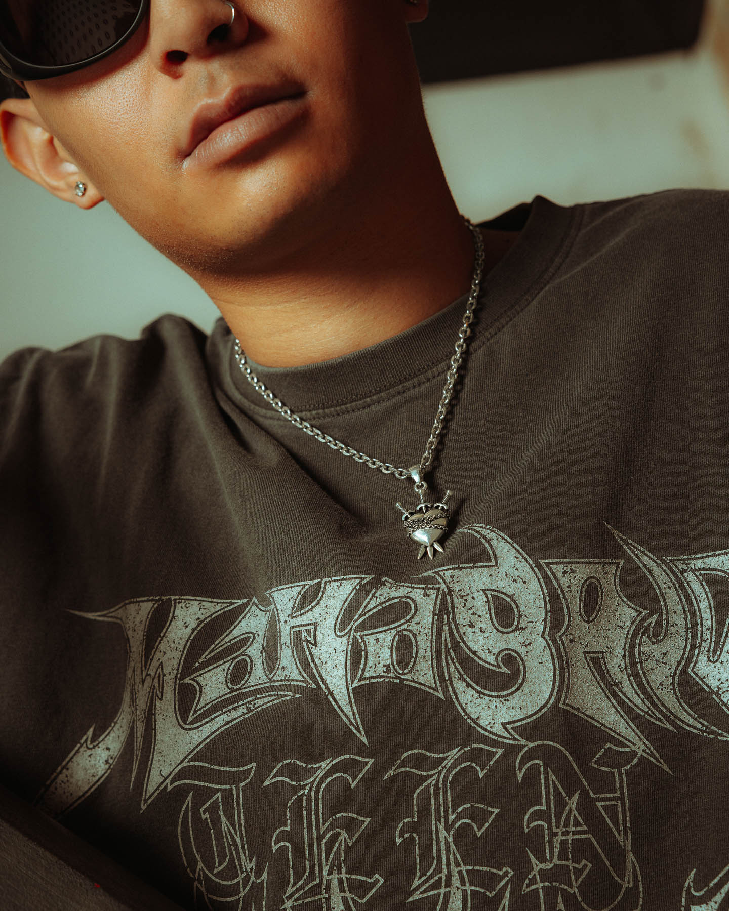 Wearing dark sunglasses and a black graphic tee, the person sports the 925 Sterling Silver "3 of Swords" Pendant—tarot jewelry shown on their lower face and upper torso.