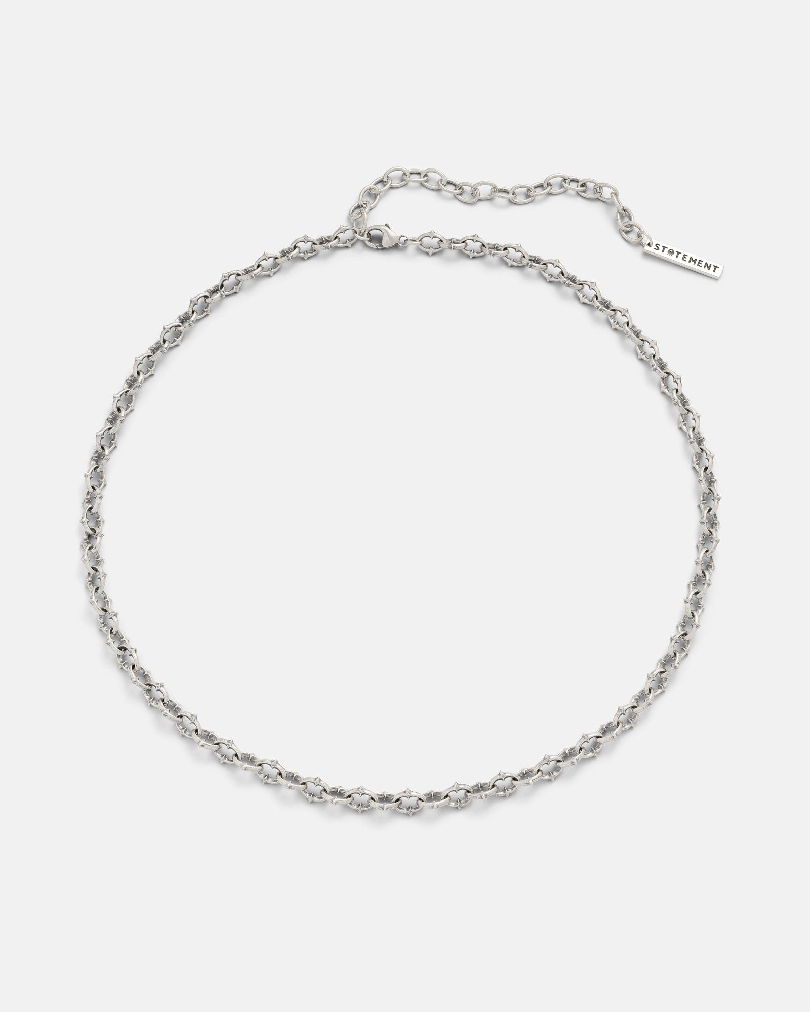 The 925 Sterling Silver "The Cathedral" 6mm Spiked Chain is a bold chain choker featuring textured, evenly spaced spikes and an adjustable clasp with a rectangular STATEMENT-engraved tag.