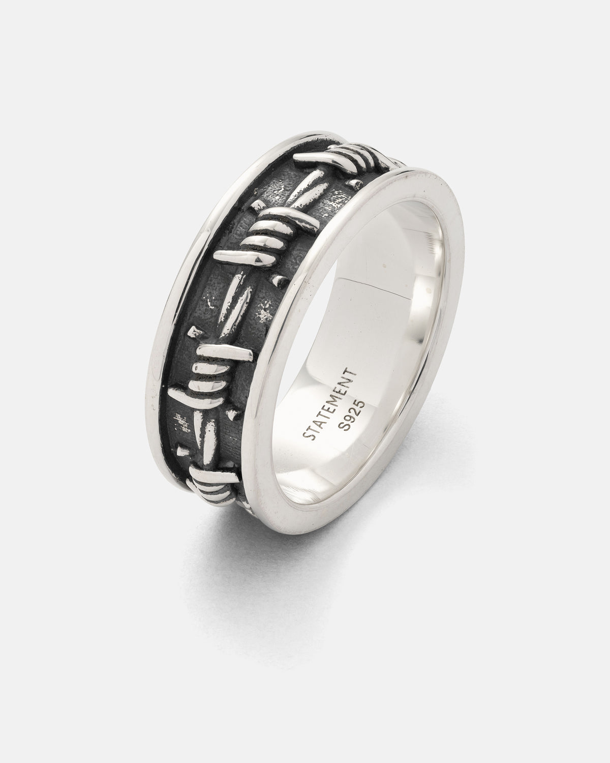 Introducing the 925 Sterling Silver Barbed Wire Ring from Statement Collective—a bold, eye-catching piece crafted to mimic barbed wire coiling around your finger. This ring features a distinctive 3D barbed wire band and is finished with a STATEMENT S925 engraving inside. Wear it solo as a unique statement accessory or stack it with other rings to effortlessly elevate any outfit.