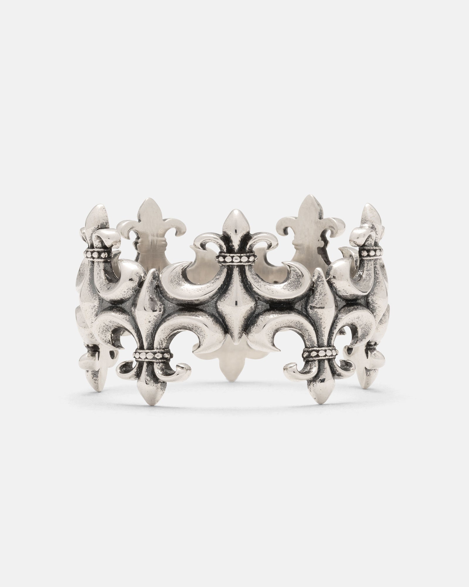 The 925 Sterling Silver “Crested” Fleur De Lis Ring by Statement Collective showcases an ornate, crown-inspired design with multiple fleur-de-lis motifs and delicate beaded accents, presented against a plain white background—a striking piece of vintage-style silver jewelry.