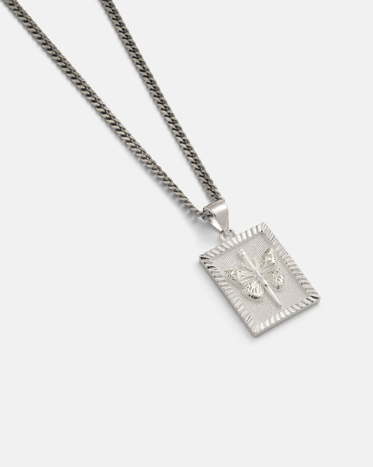 The Statement Collective 925 Sterling Silver Mini Butterfly Tag Pendant is a striking piece of jewelry, featuring a rectangular silver pendant embossed with a delicate butterfly design and showcased on a plain white background.
