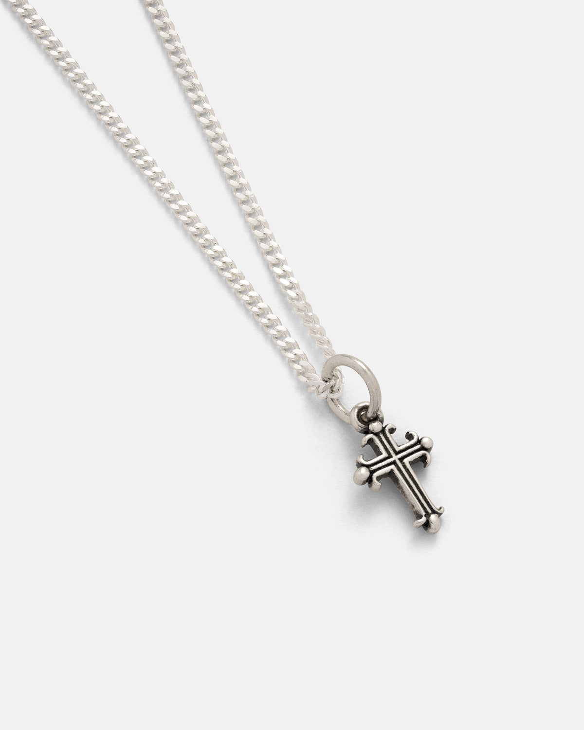 Introducing the 925 Sterling Silver Mini French Cross Pendant by Statement Collective—this silver chain necklace features a small, ornate cross pendant with round details at each tip, making it a refined addition to any sterling silver jewelry collection. Displayed on a plain white background, its subtle elegance pairs effortlessly with your favorite rock-inspired jewelry or bold skull heart pendant styles.