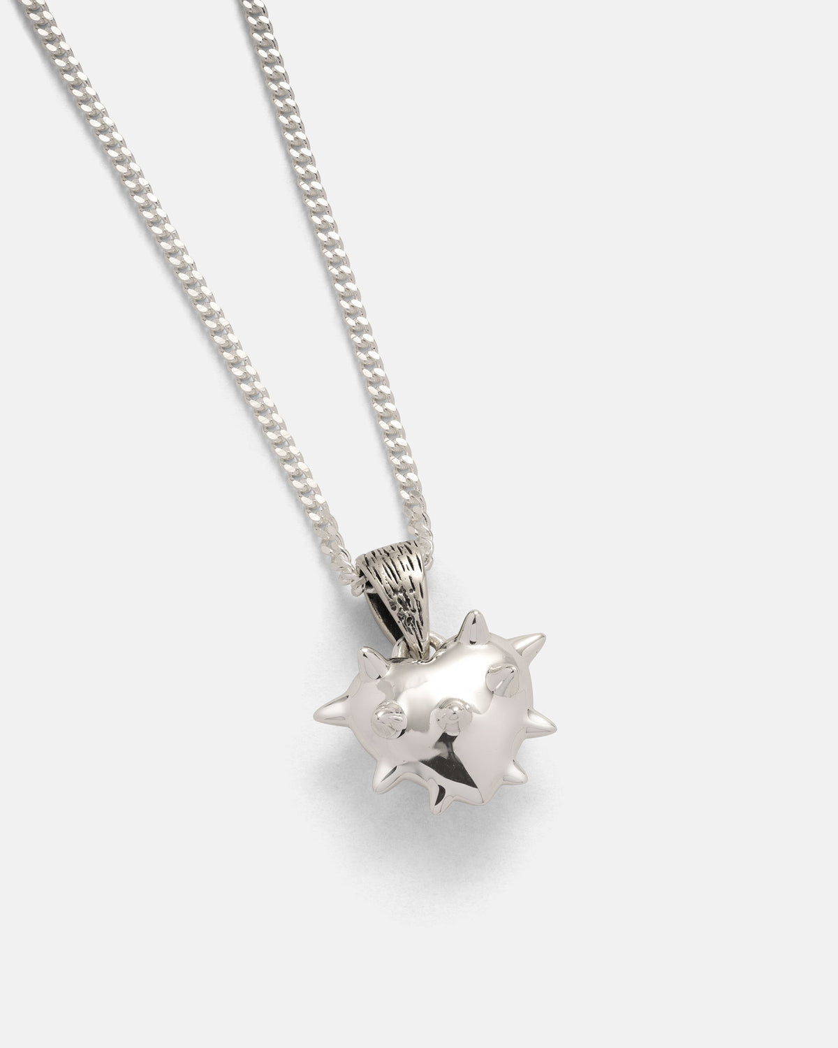 Elevate your rock jewelry collection with the 925 Sterling Silver Mini "Love Hurts" Pendant by Statement Collective—a striking chain necklace featuring a gleaming, spiked round pendant reminiscent of a stylized sea mine or pufferfish, elegantly displayed against a plain light gray background.