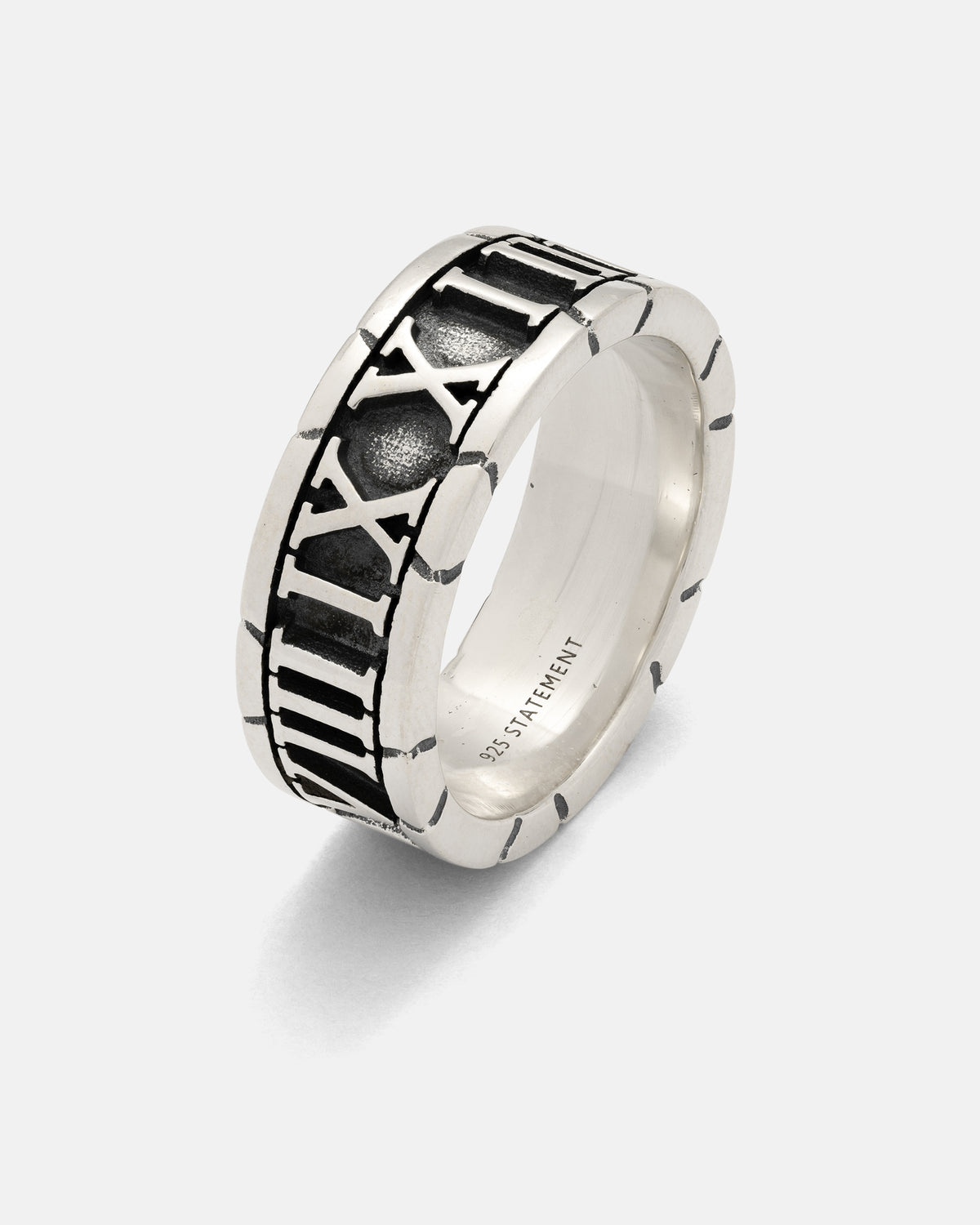 Introducing the 925 Sterling Silver Numerals Ring by Statement Collective—a handmade sterling silver ring with striking black accents and engraved Roman numerals encircling the band. The inner band is finely engraved with “STATEMENT.” This bold, modern piece of jewelry blends rustic elegance with contemporary design.