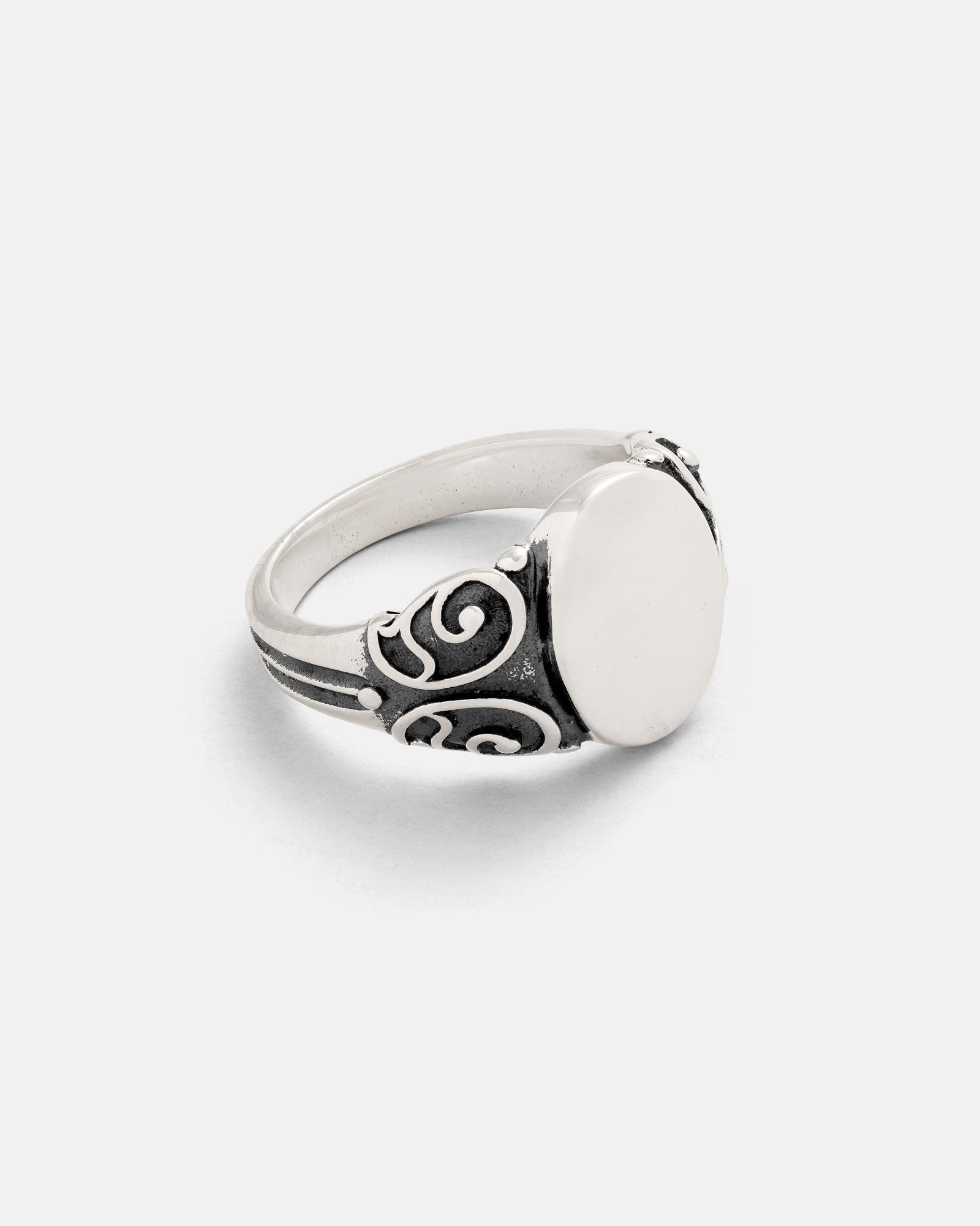 The 925 Sterling Silver Mini Oval Scroll Signet Ring features a smooth, blank oval face and ornate swirling patterns on the band, shown against a plain white background.