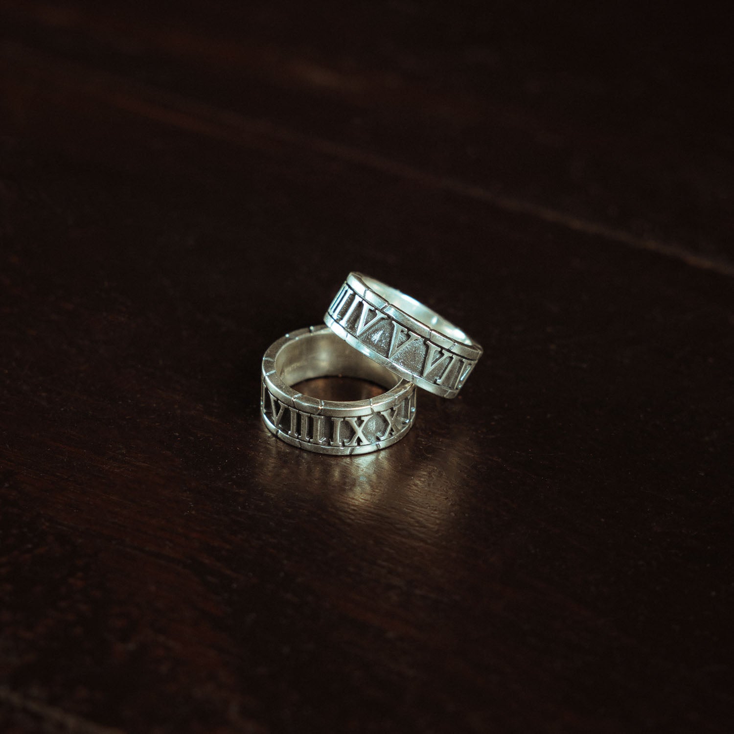 Sterling Silver band rings stacked on top of eachother with roman numerals the entire way around it.