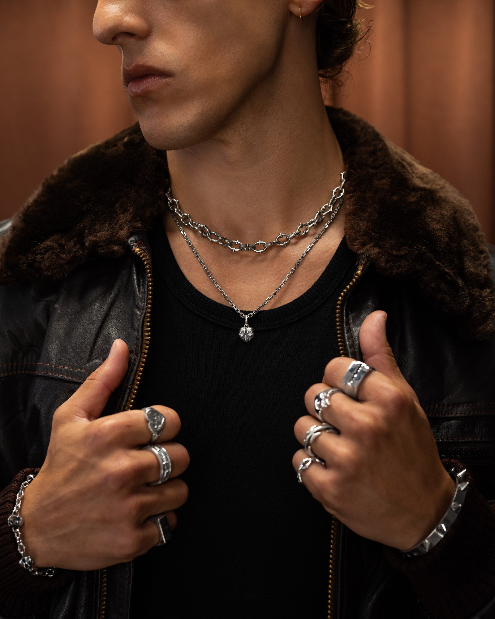 man with black leather jacket wearing sterling silver skull heart pendant by statement collective