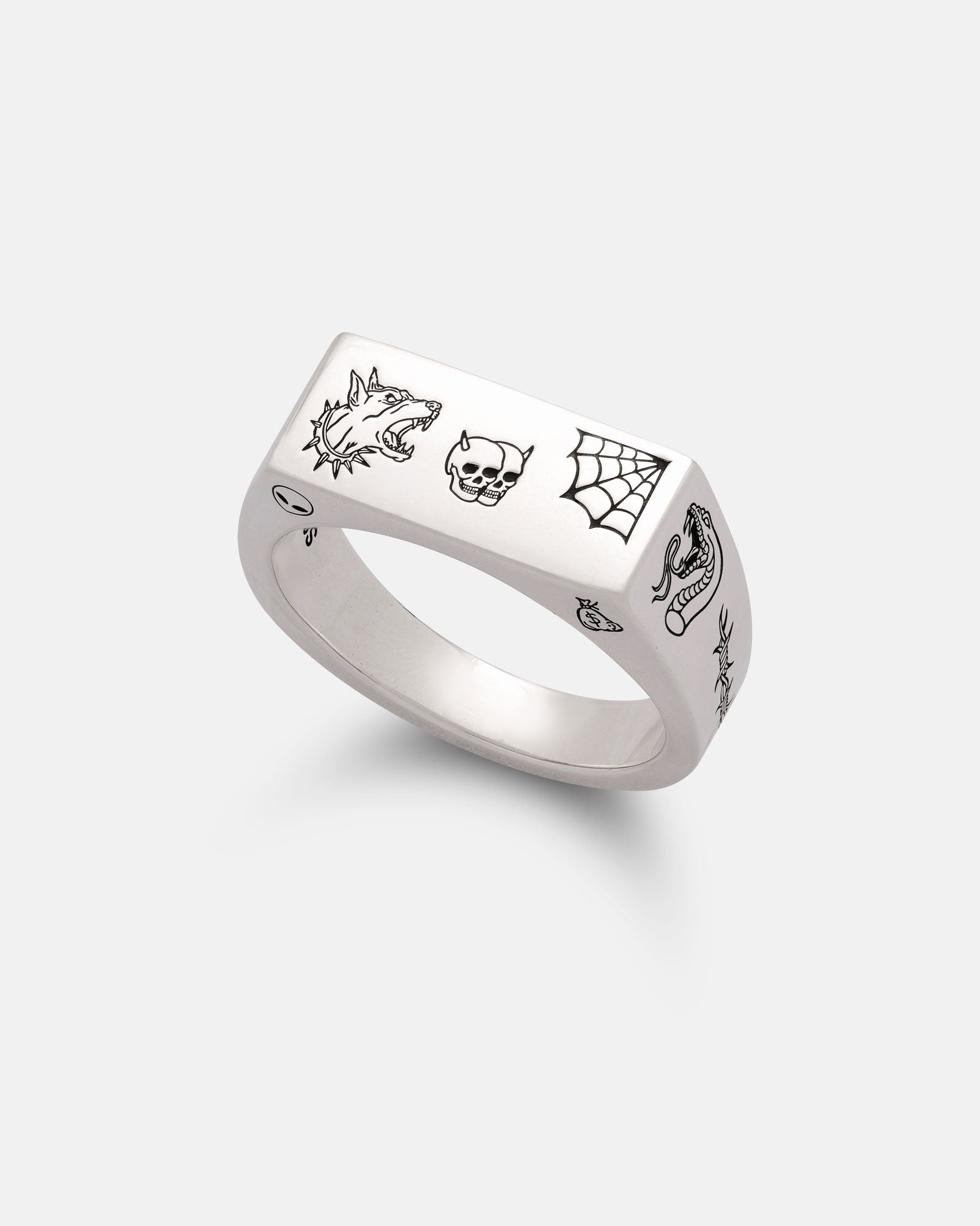 The Statement Collective 925 Sterling Silver Tattoo Signet Ring features a rectangular top engraved with black line art of a wolf, skull, and spiderweb, plus side details of a snake and an eye.