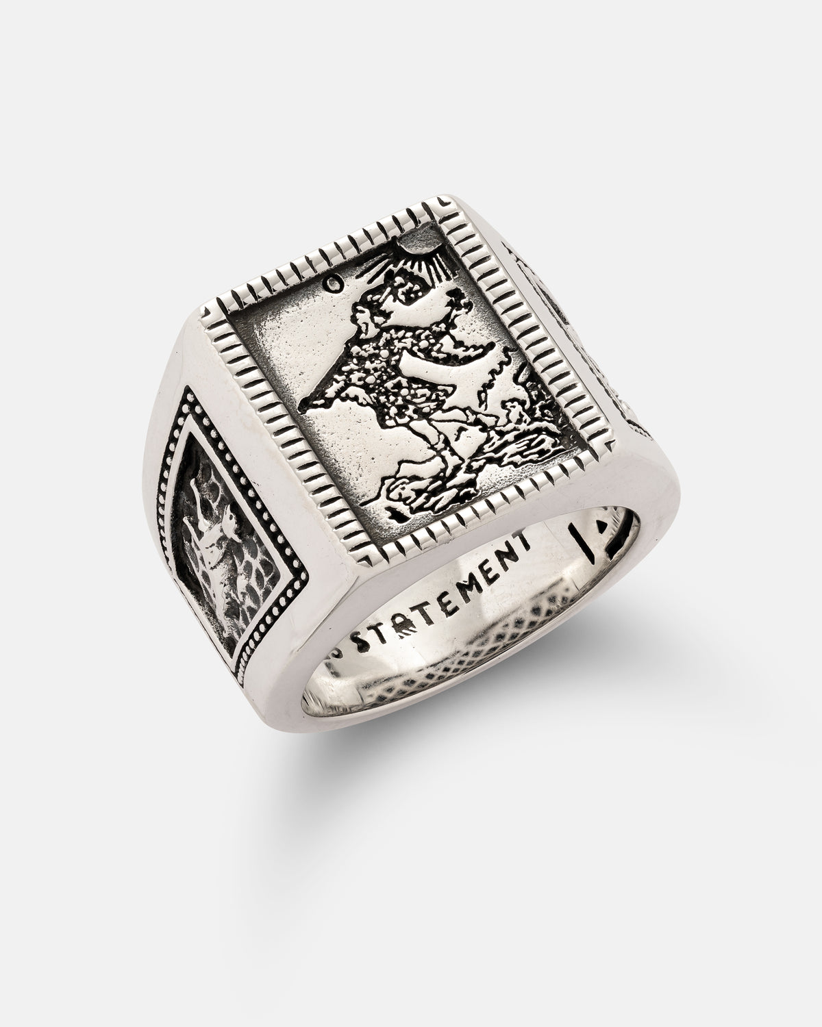Statement Collective 925 Sterling Silver Try Hard Fool signet ring featuring a rectangular face with an embossed figure of a traveler and engraved designs on the sides.