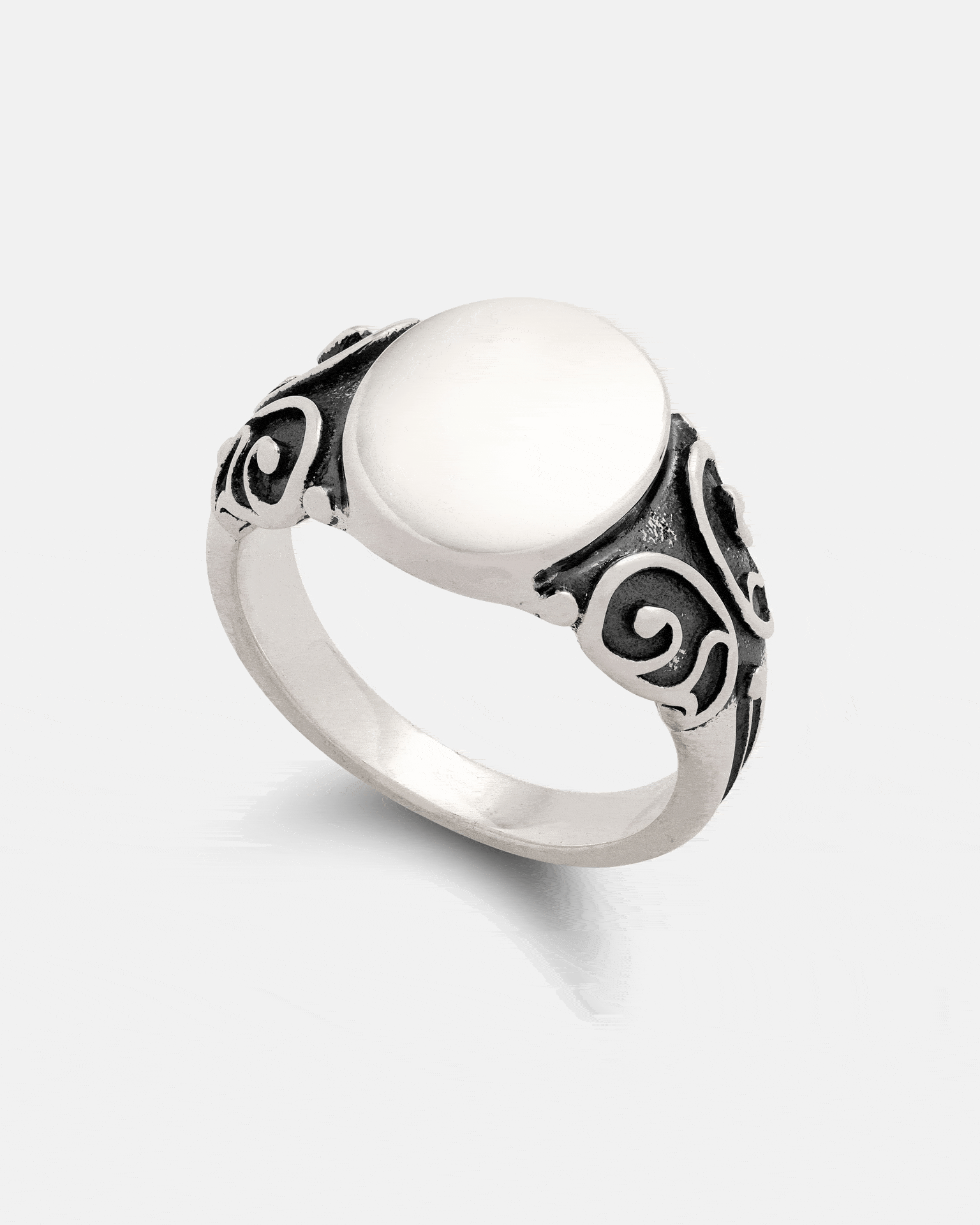 The Statement Collective 925 Sterling Silver Mini Oval Scroll Signet Ring features a smooth, oval flat top and intricate black scrollwork detailing on the band, displayed on a plain white background.