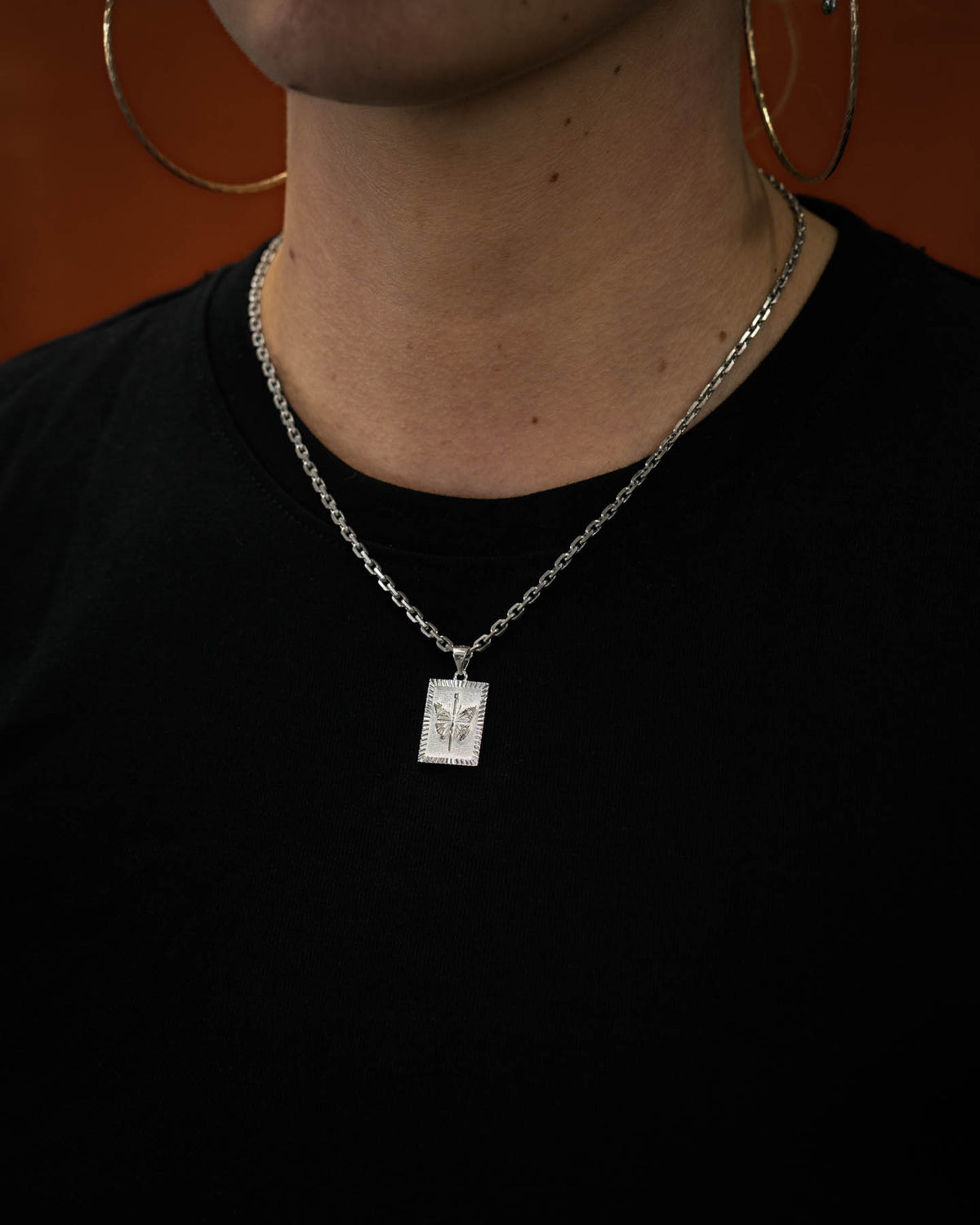 female model wearing 925 sterling silver butterfly pendant against orange background