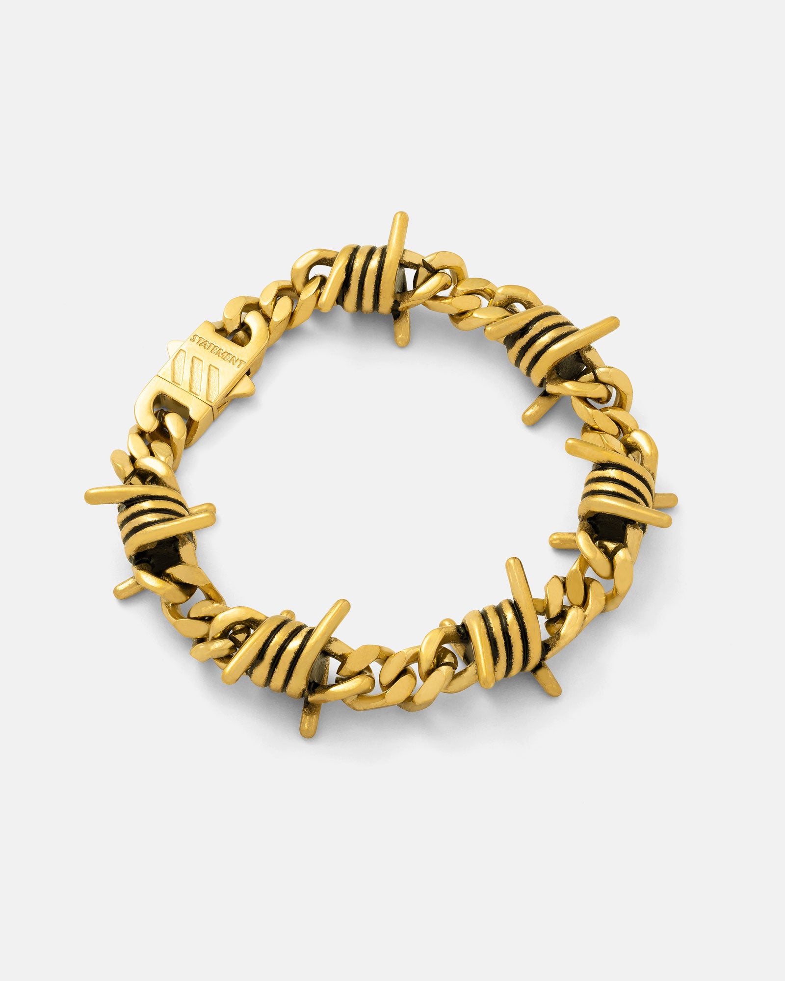 Gold 9mm Barbed wire bracelet by statement collective on grey background.