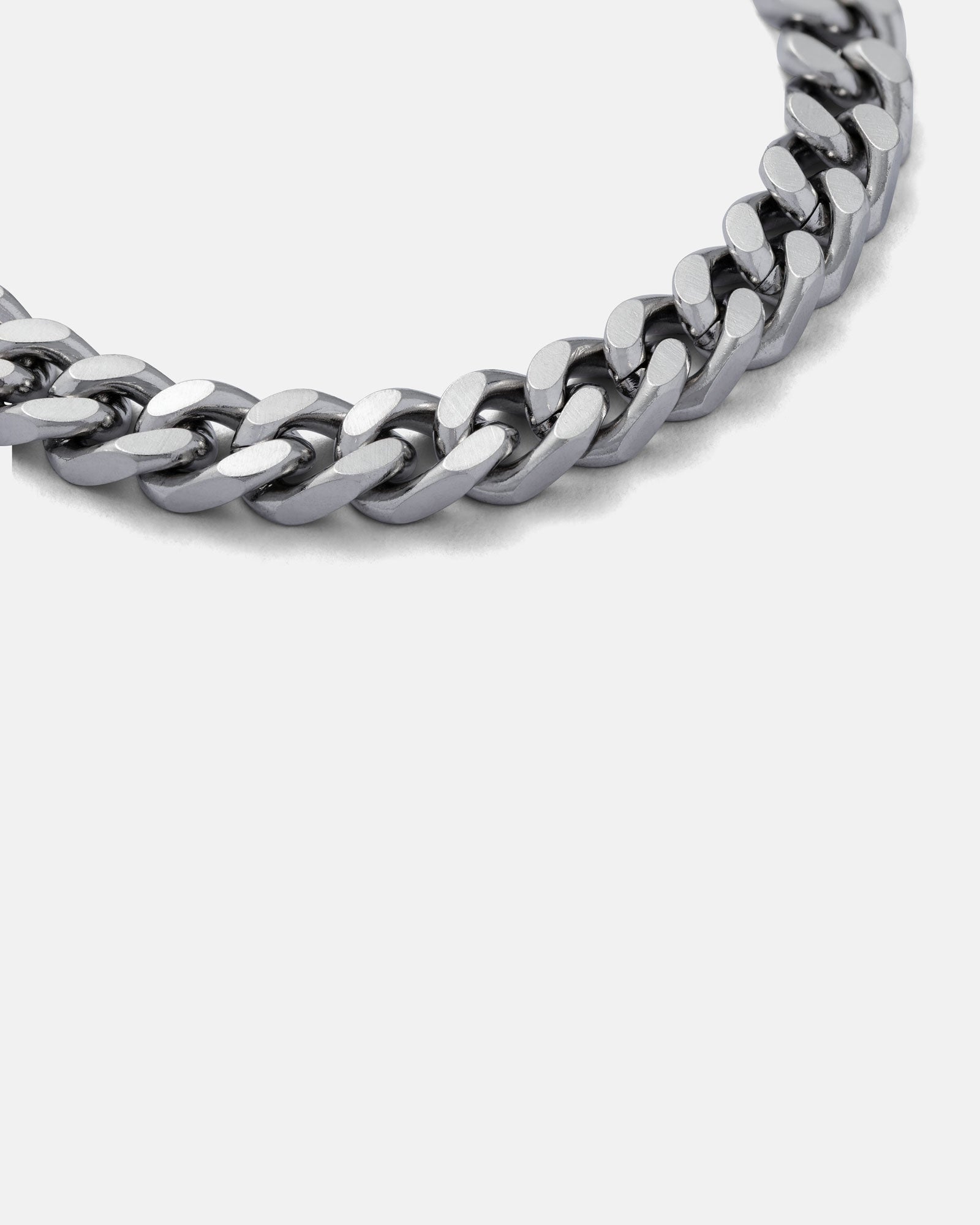 Close-up of the 9mm Cuban Bracelet against a plain grey background, highlighting its thick, interlocking polished silver links. This non-tarnish bracelet promises lasting shine and durability.