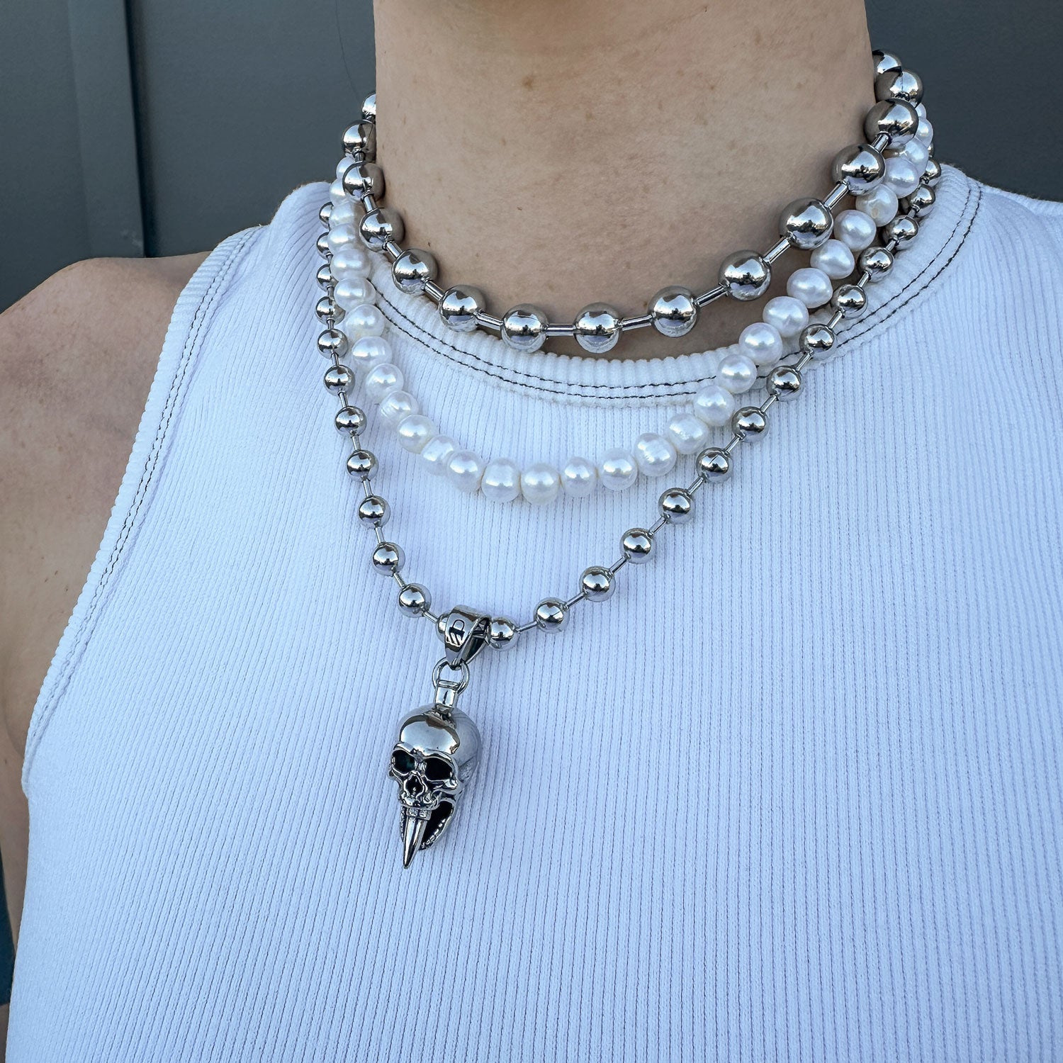 Gothic Silver necklace set with skull jewelry and pearls on females body by Statement Collective