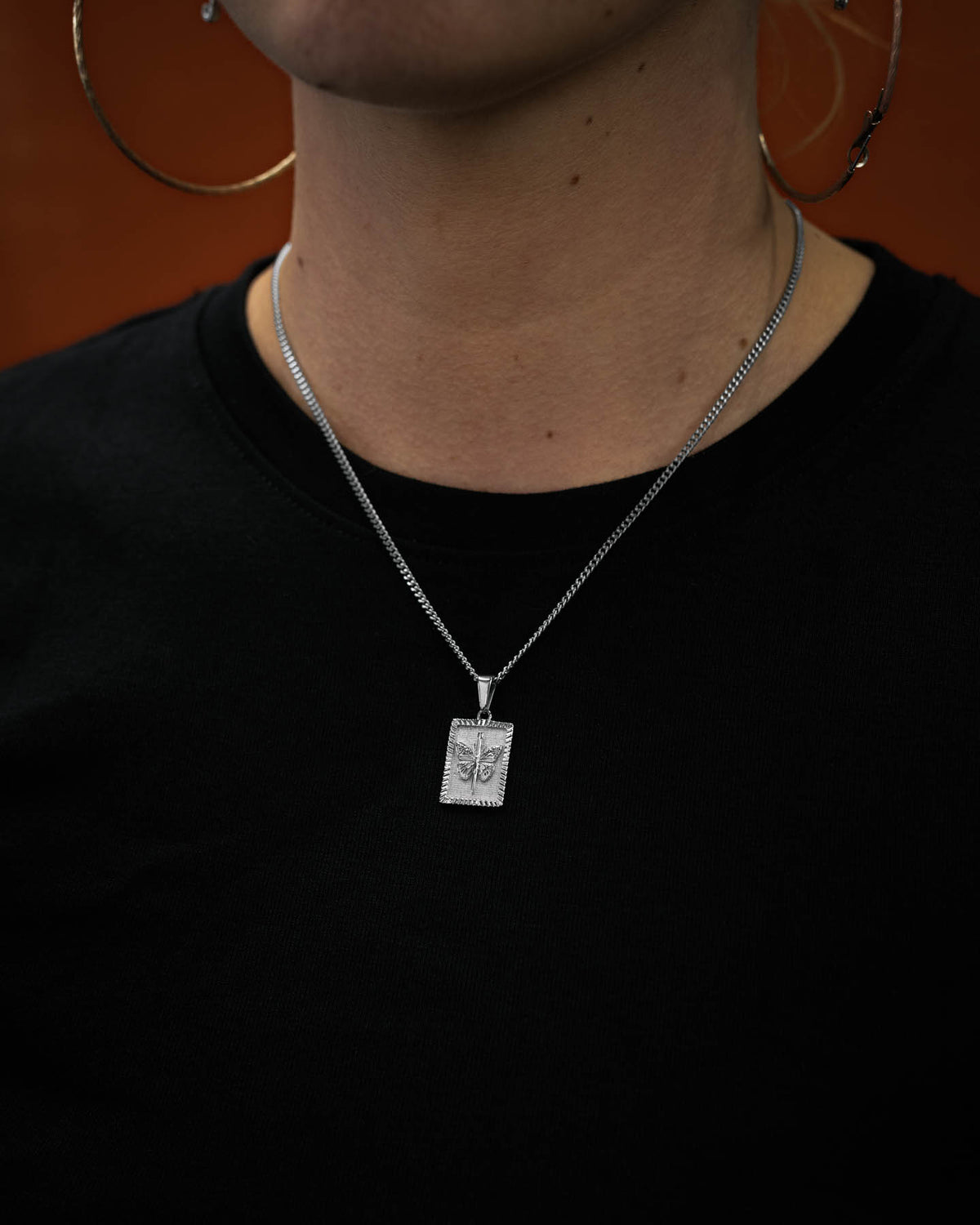 female model wearing mini butterfly tag pendant by statement collective