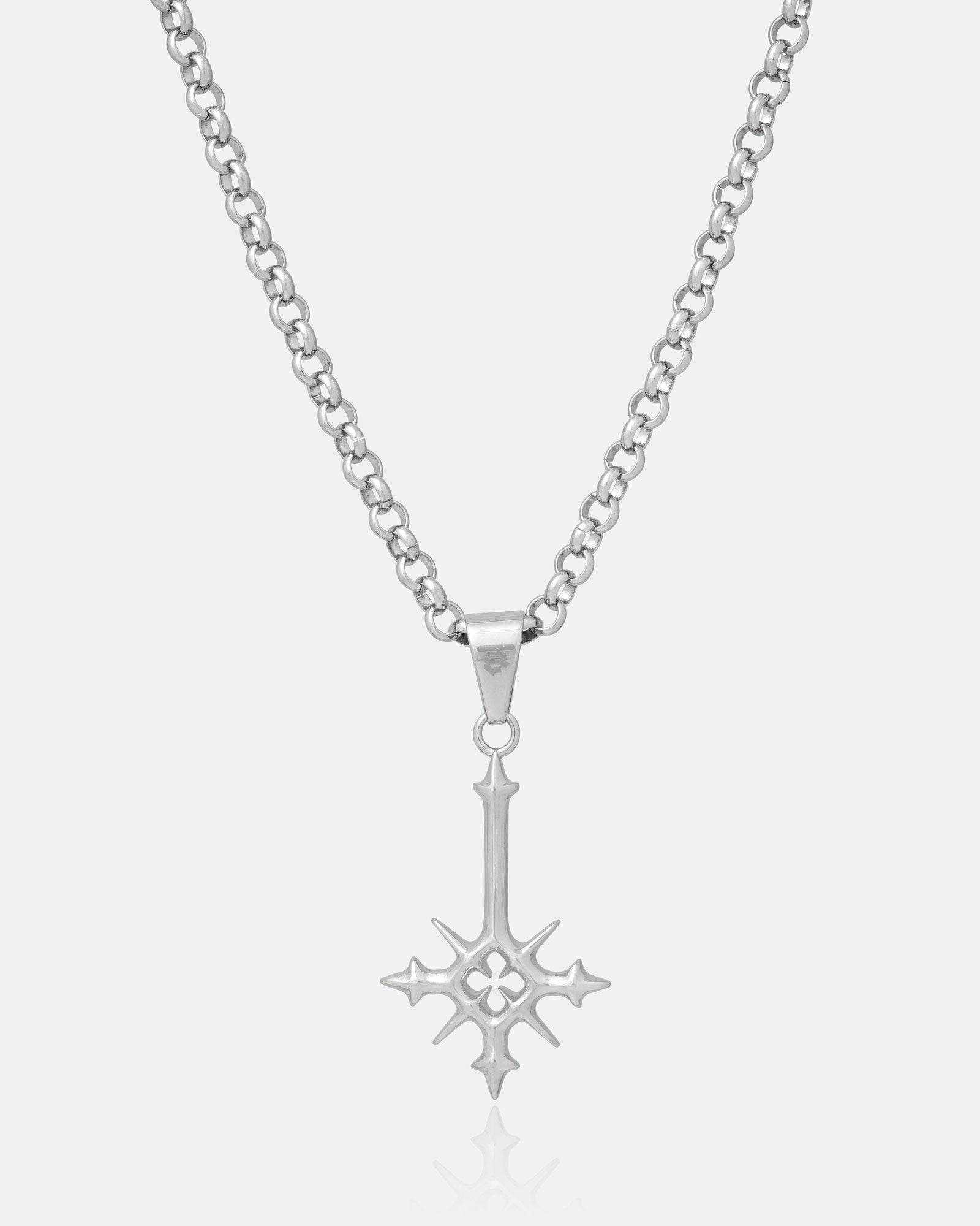 Silver inverted cross pendant with spikes hanging on white background