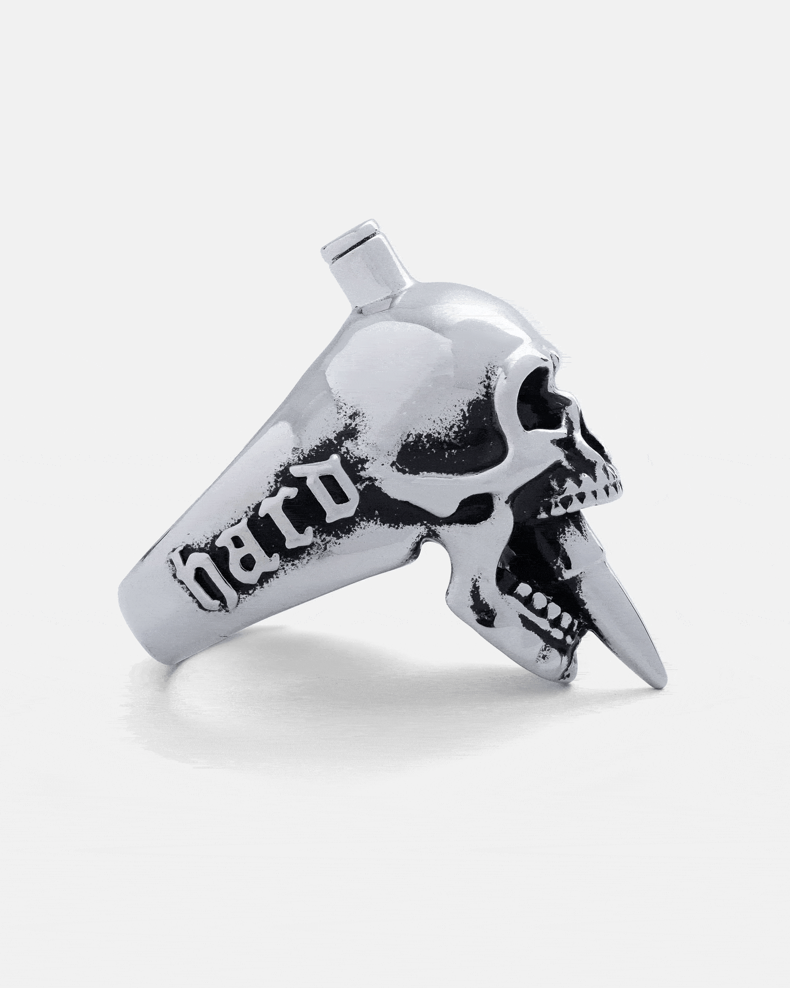 The "Bite The Bullet" Ring by Statement Collective is a silver skull ring with a spike through its mouth and "hard" engraved on the band—ideal for fans of bold rock jewellery.