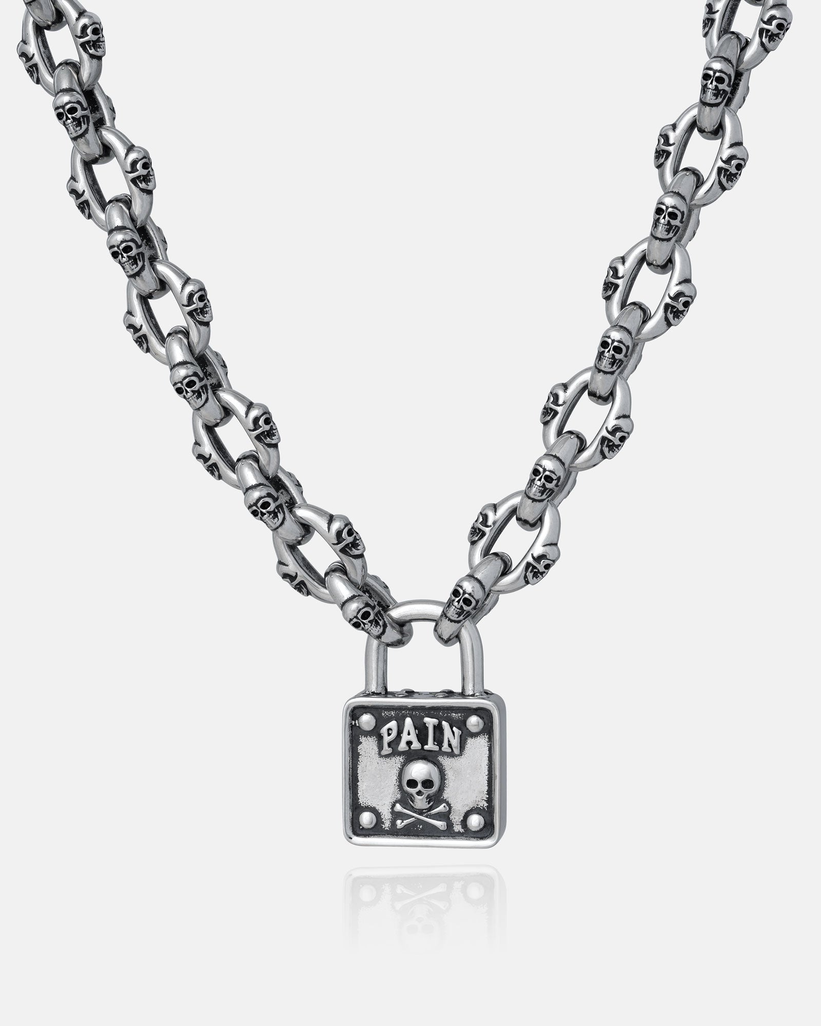 The "Boneyards" Skull Padlock Chain features a stainless steel 12mm cable chain with small skull links and a rectangular padlock pendant engraved with PAIN above a skull and crossbones.