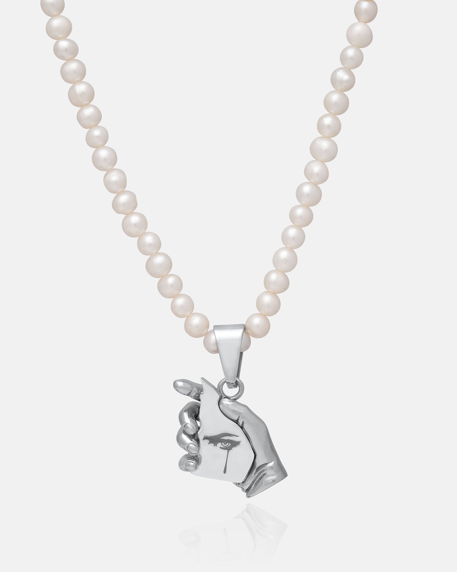 The Freshwater Pearl Necklace With Custom Pendant Choice features waterproof pearls and a silver charm shaped like a hand holding an engraved eye and tear, blending unique design with elegant style.