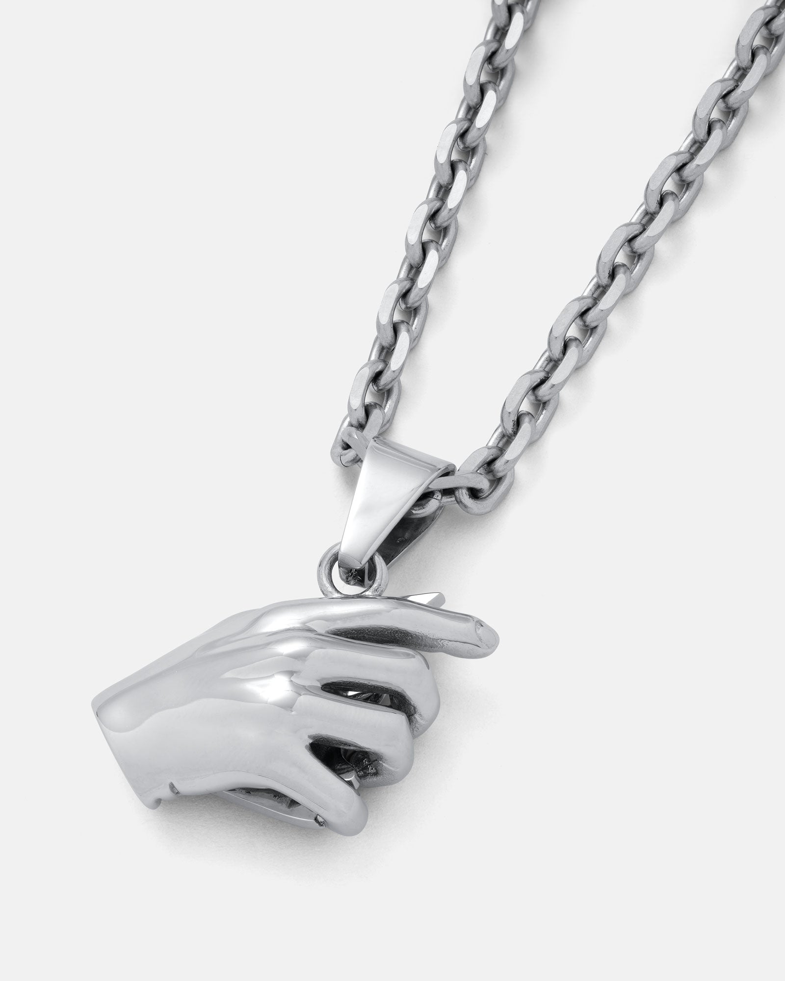 The Broken Mirror" Pendant: A silver 316L stainless steel chain necklace featuring a realistic hand-shaped pendant, artfully posed as if pinching something. Displayed on a plain white background—an avant-garde jewelry piece.