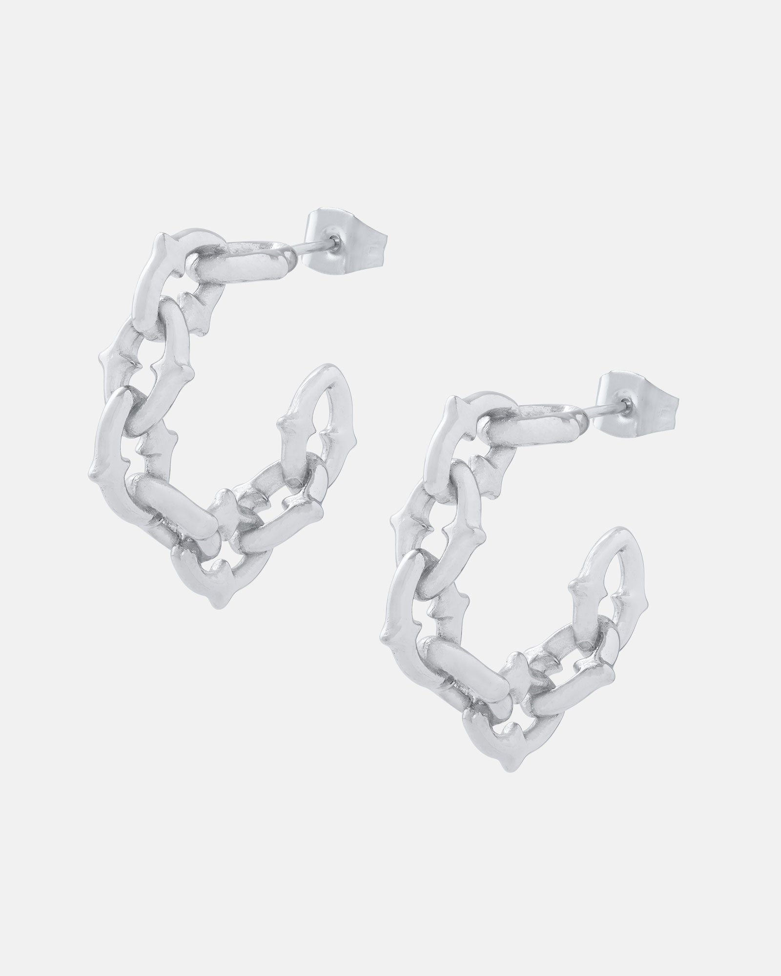 The Cathedral" Hoop Earrings feature gothic-inspired, interconnected bone-like hoops with a spiked chain link texture and jagged design. These statement earrings fasten with stud posts for a bold, edgy look.