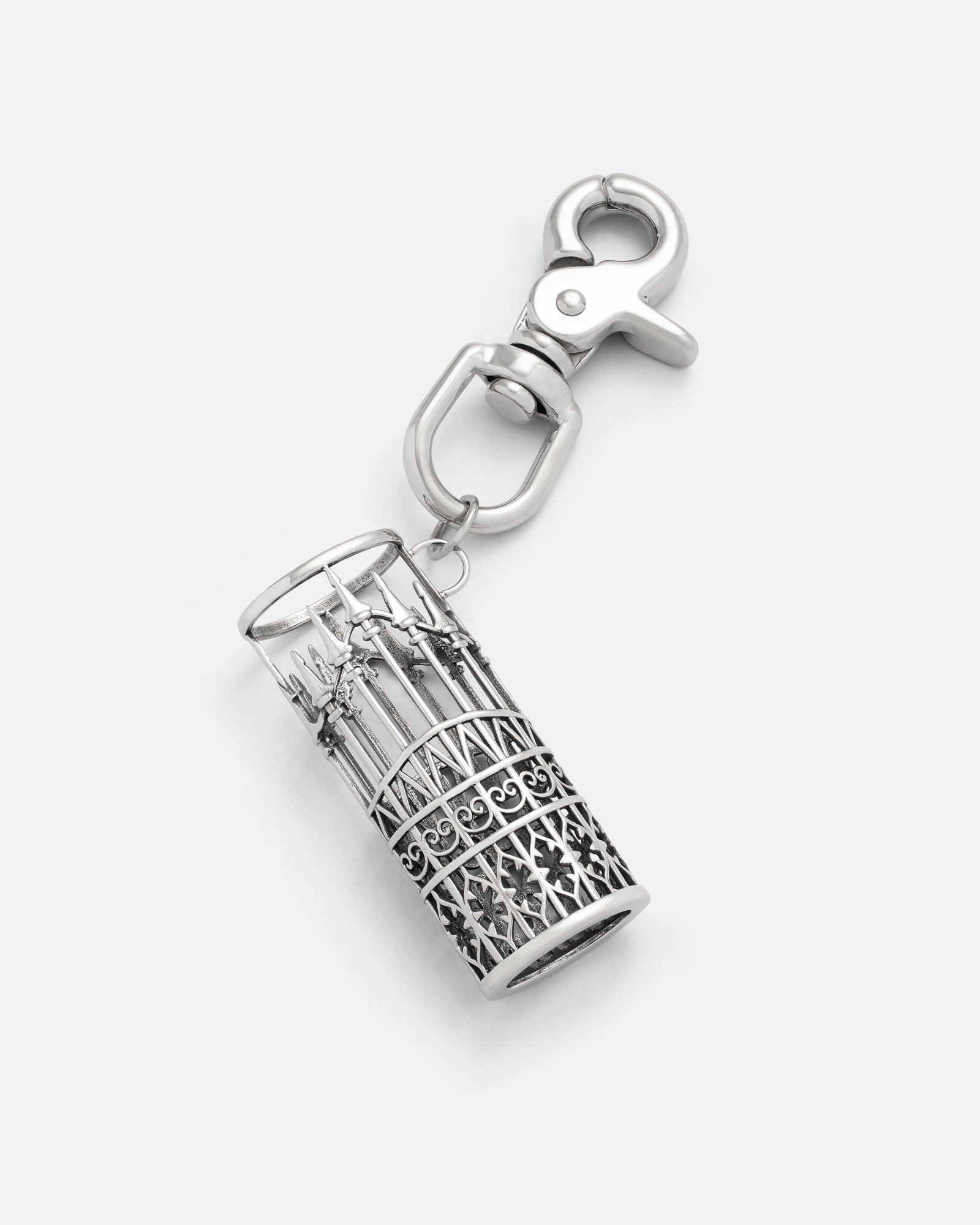 The "Wrought Iron" Lighter Sleeve by Statement Collective is crafted from 316L stainless steel in a silver finish, with a detailed cylindrical cage design featuring intricate patterns and miniature spears, secured by a lobster clasp.