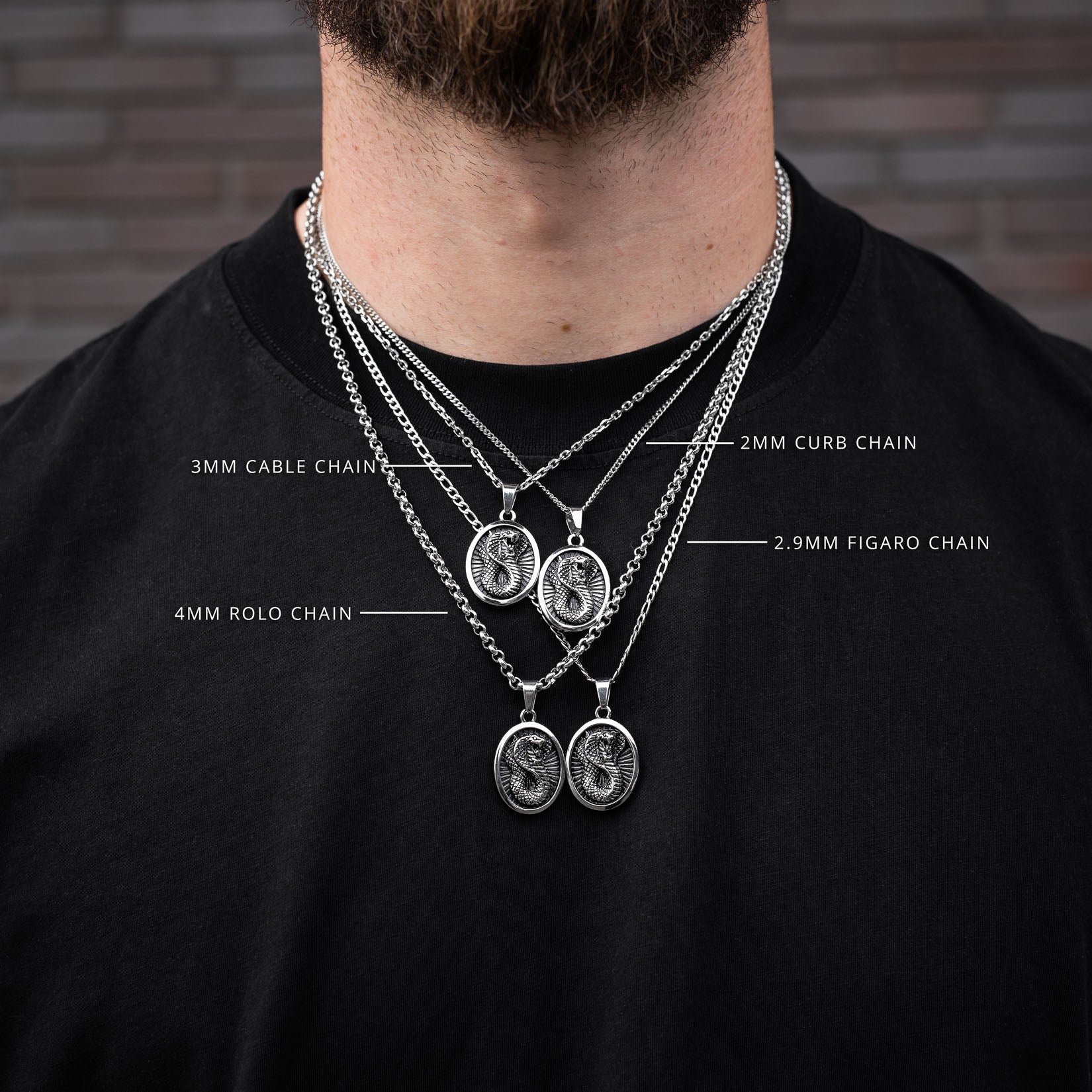Man wearing multiple silver cobra pendant chains with labeled chain types against a brick wall background.