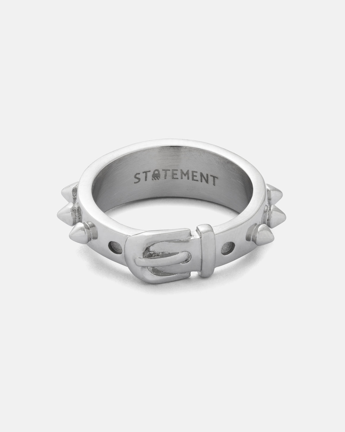 The Spiked Dog Collar Ring by Statement Collective is a silver stainless steel ring featuring engraved spikes inspired by goth rings and spiked dog collars, with the word “STATEMENT” inscribed on the inner band, displayed against a plain white background.