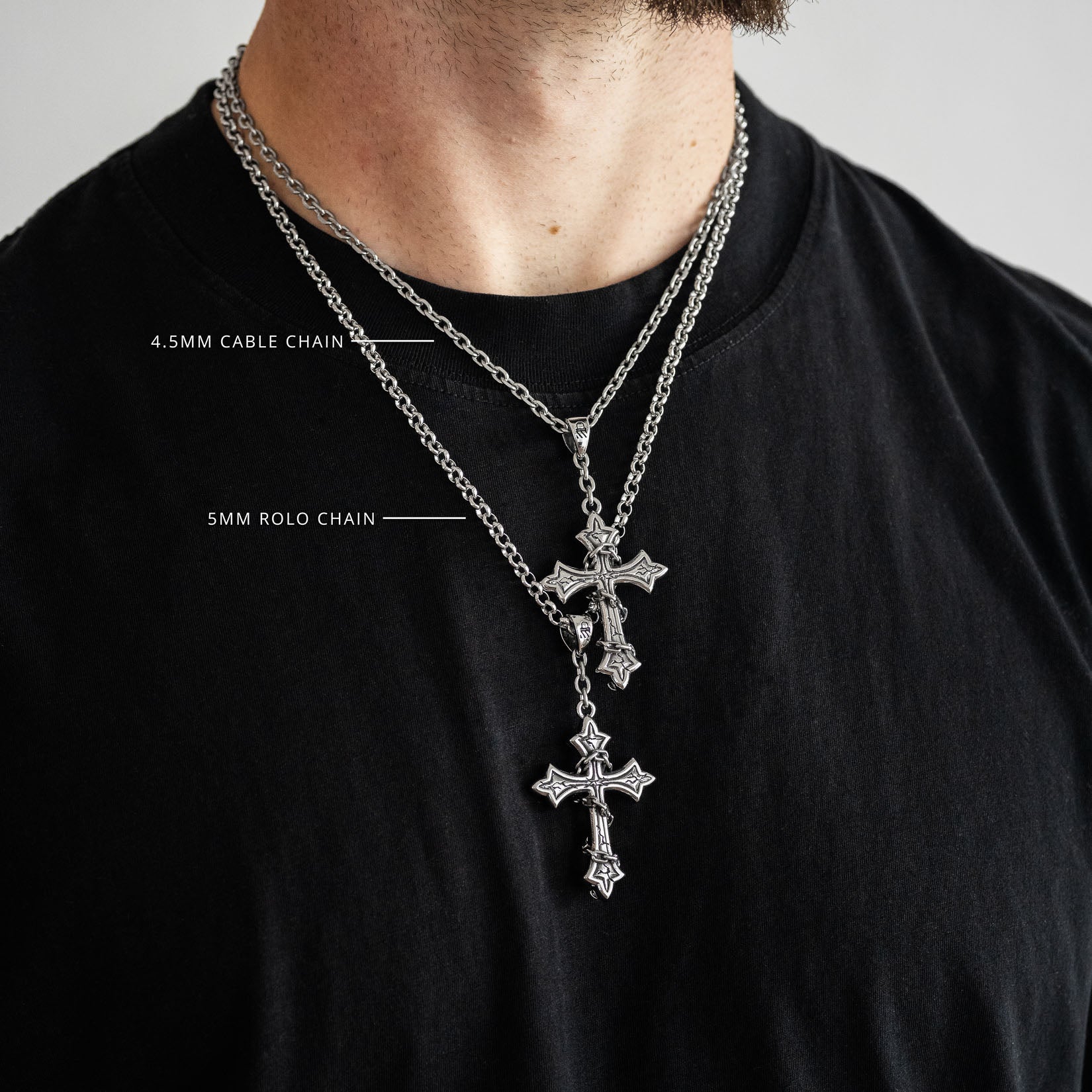 Silver chain necklace with cross pendant on a black shirt, showing chain details.