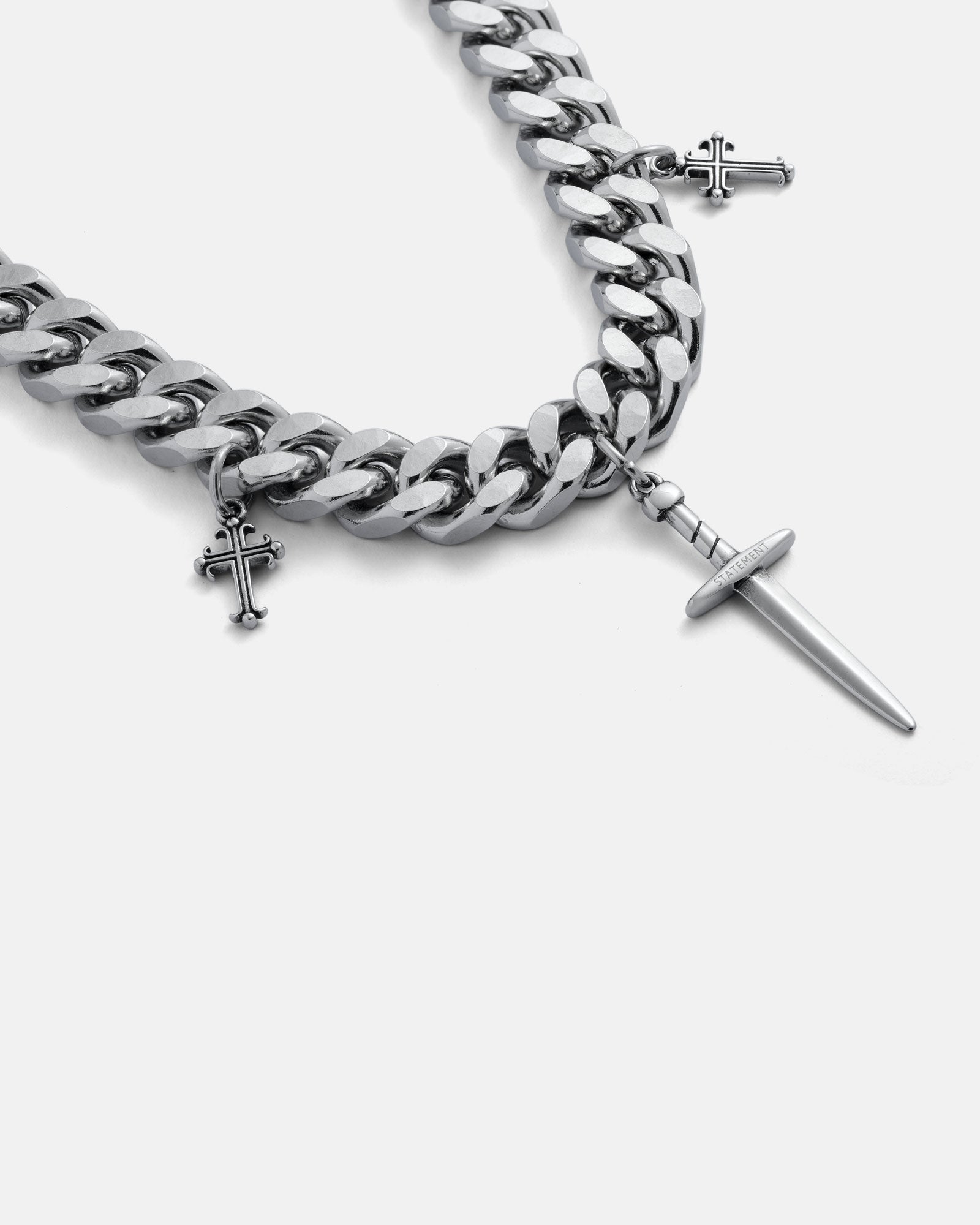 Silver chain bracelet with cross charms on a grey background