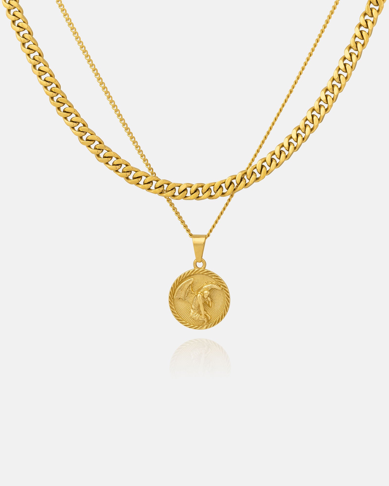 Two gold chains from the Cuban Set (Custom Pendant Choice) (Gold) are layered—one a thick Cuban link, the other a slimmer 18k gold necklace with an engraved medallion pendant of a winged figure—both shown on a white background.