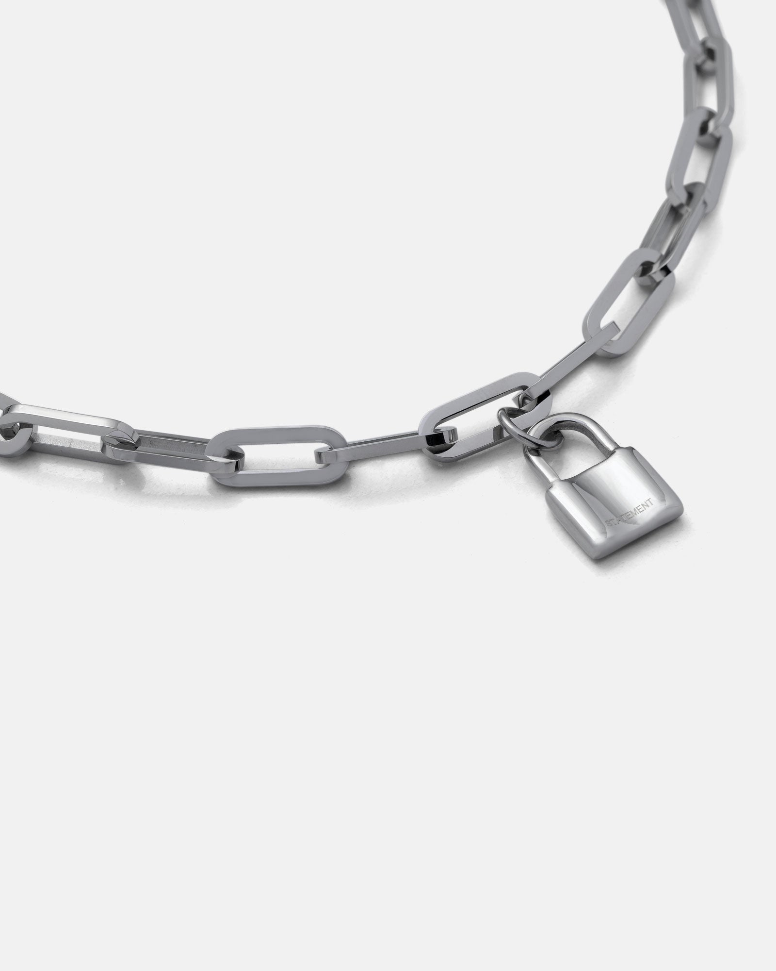 The Dainty Charm Choker (Custom Pendant Choice) is a silver paperclip chain necklace with large rectangular links and a small silver padlock charm, shown against a plain white background.