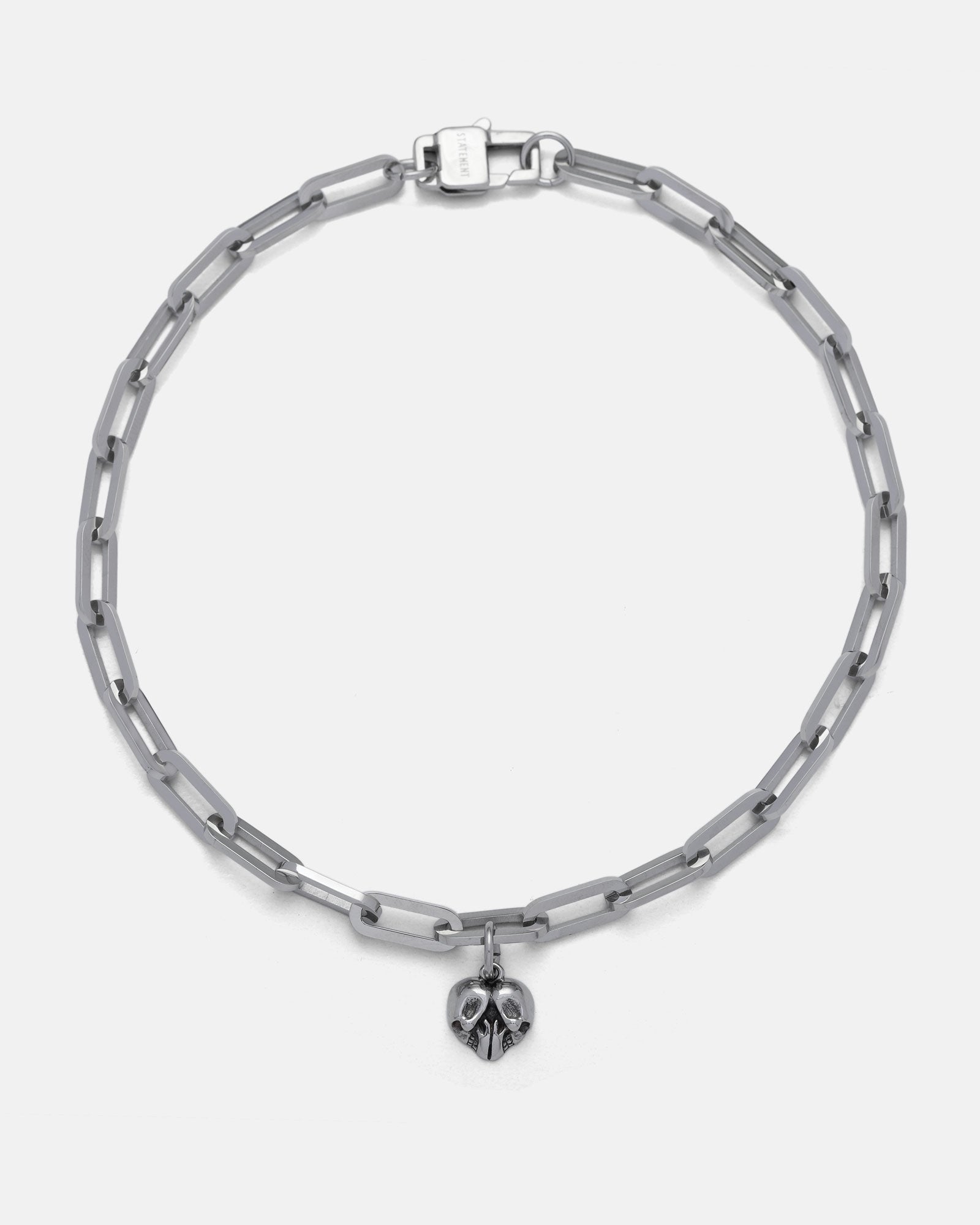 The Dainty Charm Choker features rectangular silver paperclip links with a customizable small metallic skull pendant at the center.