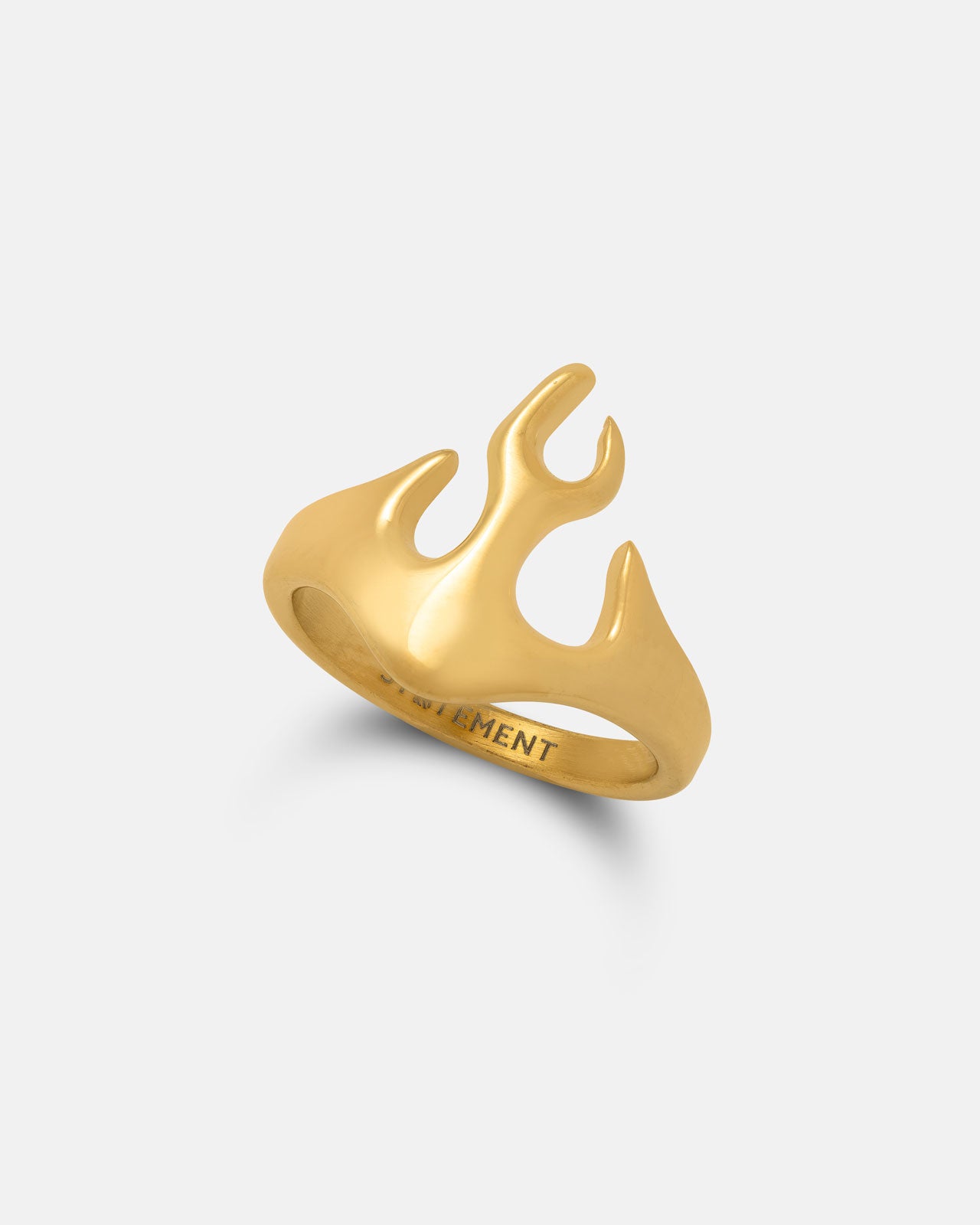 The Flame Ring (Gold) by Statement Collective features a bold, flame-inspired design with three upward-pointing prongs and engraved text on the interior, displayed against a simple light background.