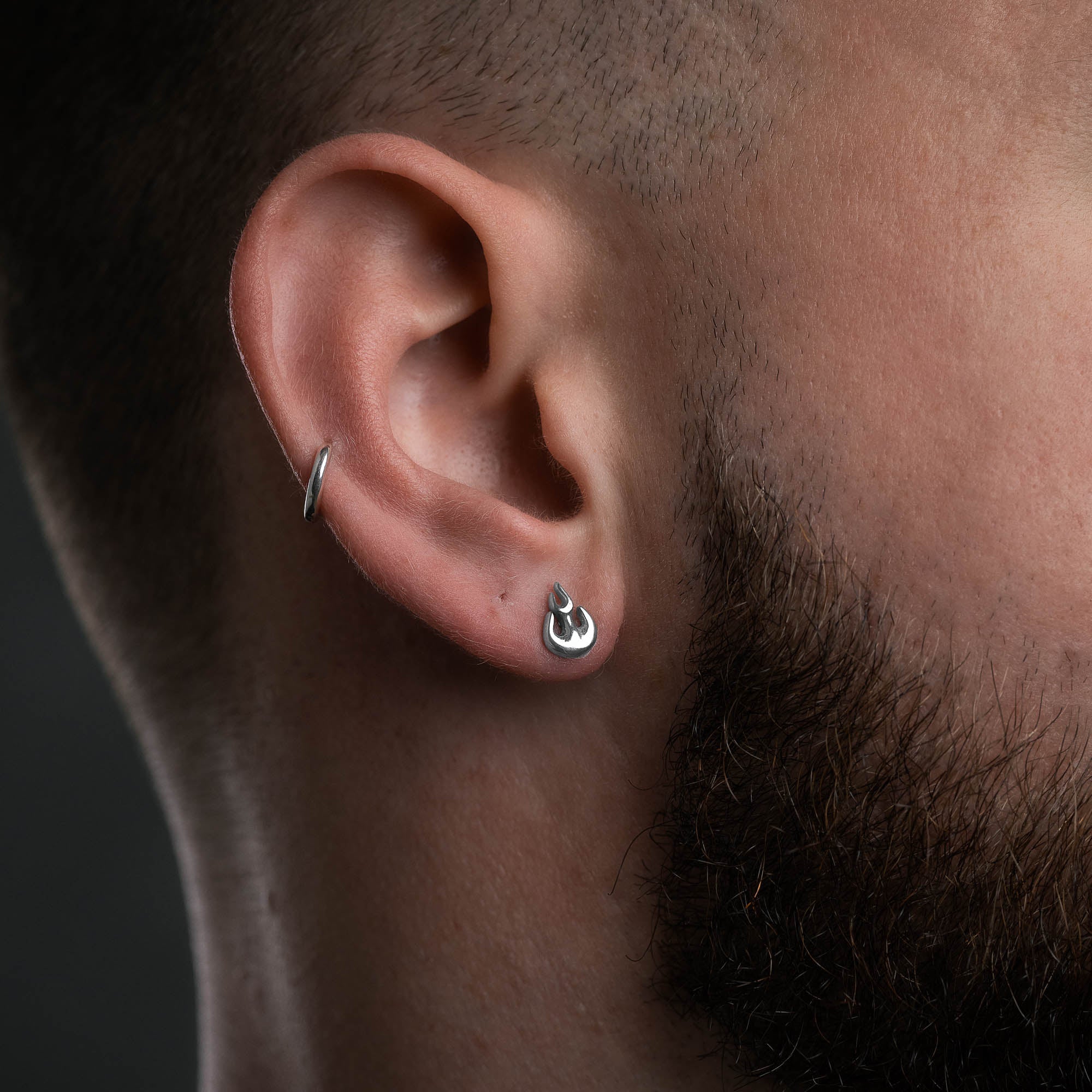 Silver flame stud earring, on male model