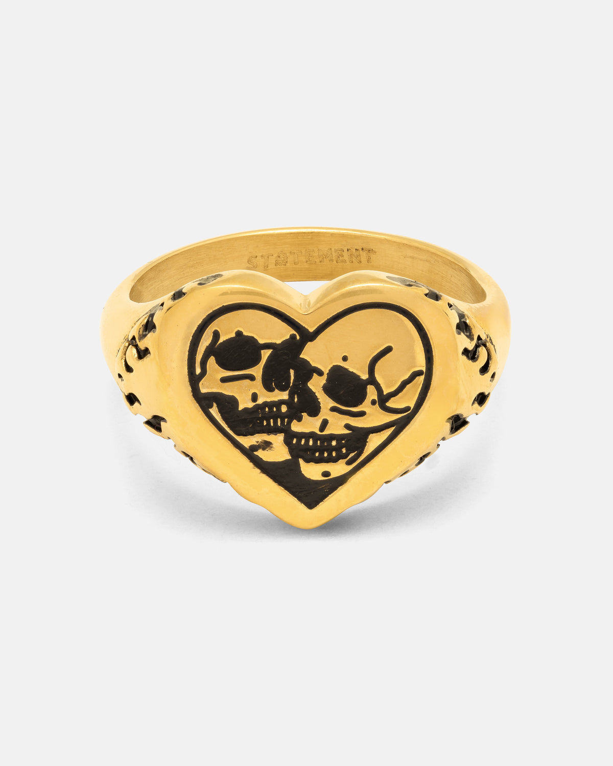 Introducing the Skull Heart Ring (Gold) by Statement Collective—a bold heart-shaped ring featuring two black-etched skulls facing each other at its center and intricate decorative markings along the band. Finished with an 18k gold plated sheen, this striking piece of gothic jewellery is sure to make a statement.
