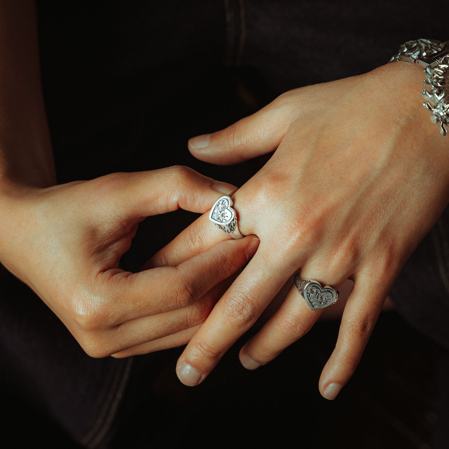 Sterling Silver heart shaped ring with skulls and flames on male model