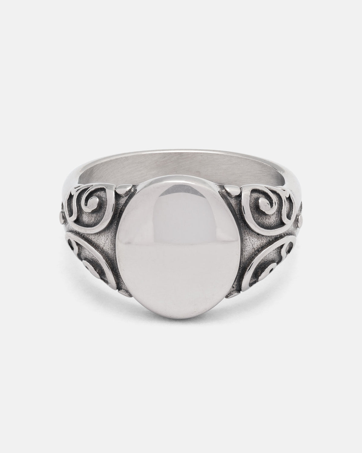 The Mini Oval Scroll Signet Ring by Statement Collective features a polished silver centerpiece and an ornate traditional scroll pattern swirling along the band, displayed on a plain white background.