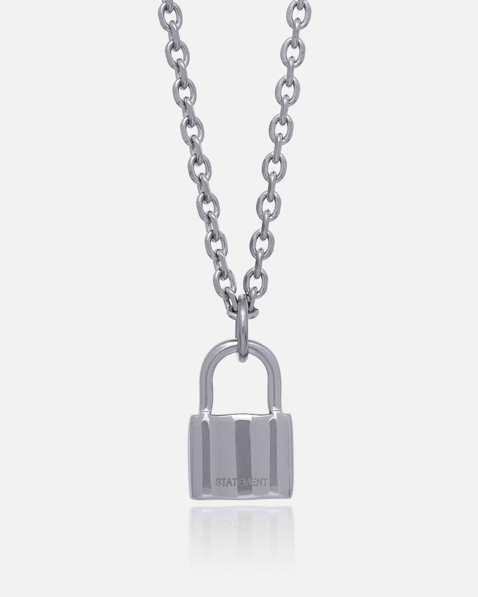 The Mini Padlock Pendant is a silver necklace with a 2mm chain, featuring a padlock-shaped pendant engraved with "STATEMENT," shown on a plain white background.