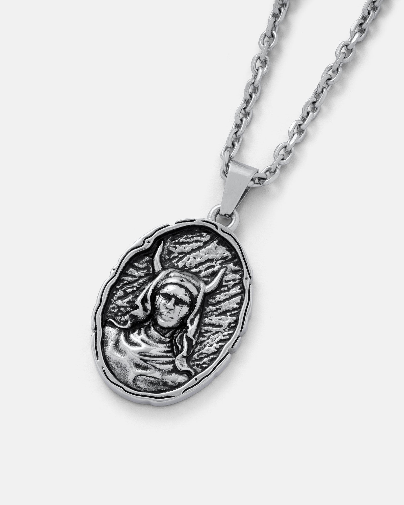 The Unholy" Pendant is an oval gothic necklace with a raised, detailed hooded figure with horns on a textured background, hanging from a silver interlocking-link chain.