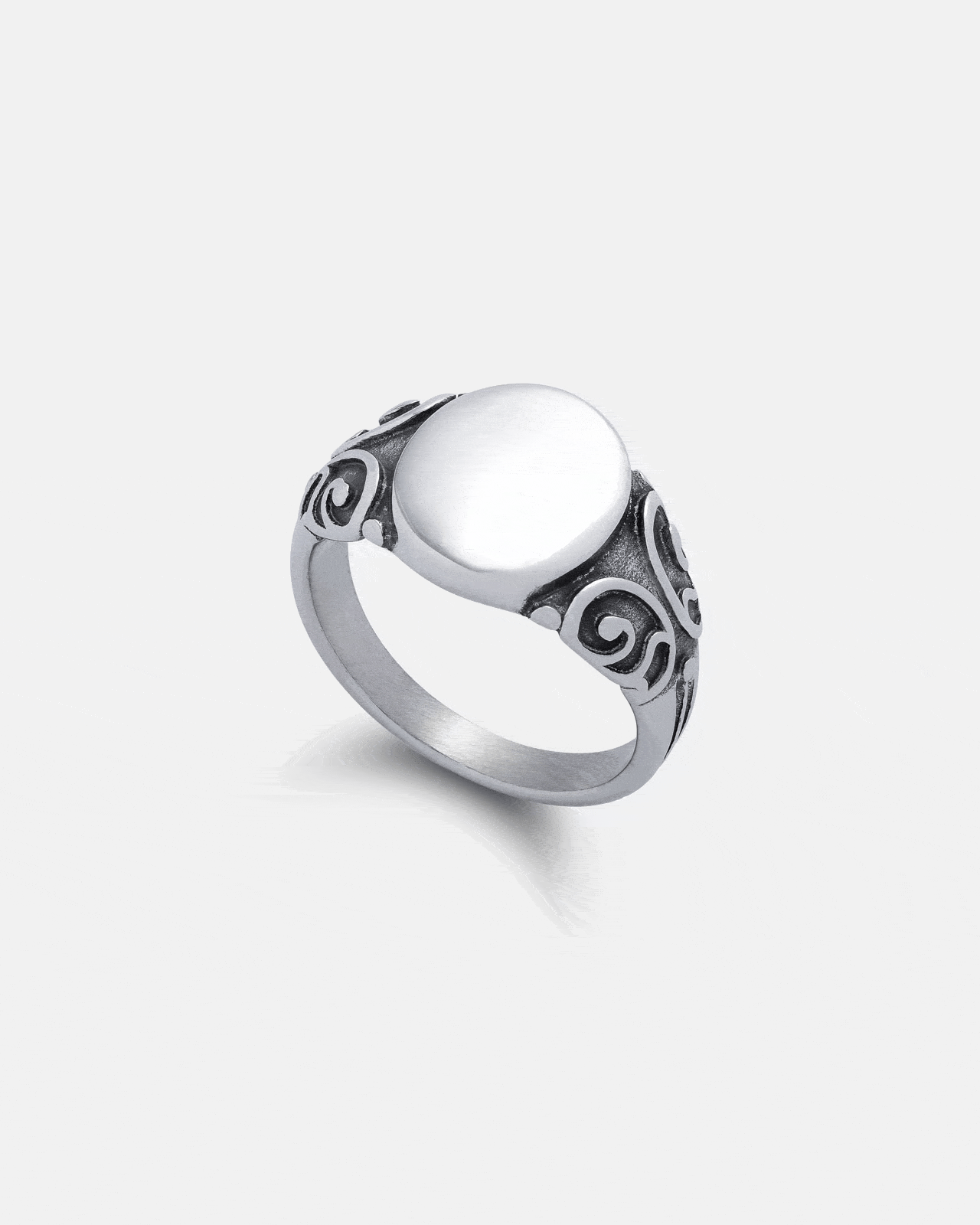 The Mini Oval Scroll Signet Ring by Statement Collective features a plain, oval flat top and ornate scroll patterns on the band, shown against a light grey background.