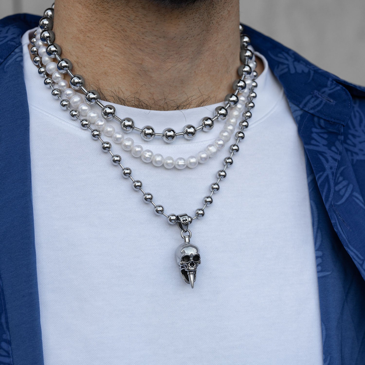 Gothic silver necklace set with skull pendant and pearls on mans body by Statement Collective