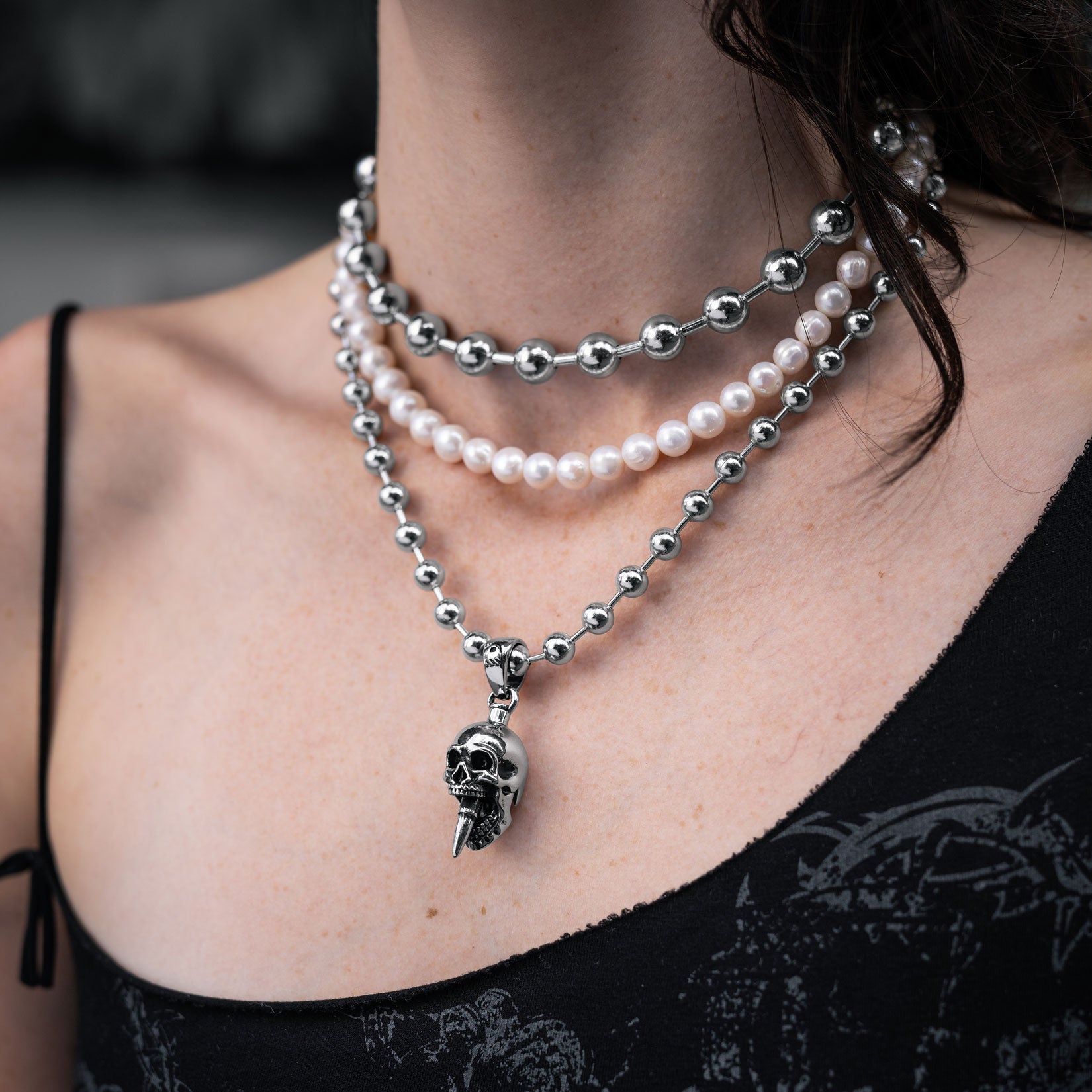 Gothic silver necklace set with skull pendant and pearls on a females body by Statement Collective