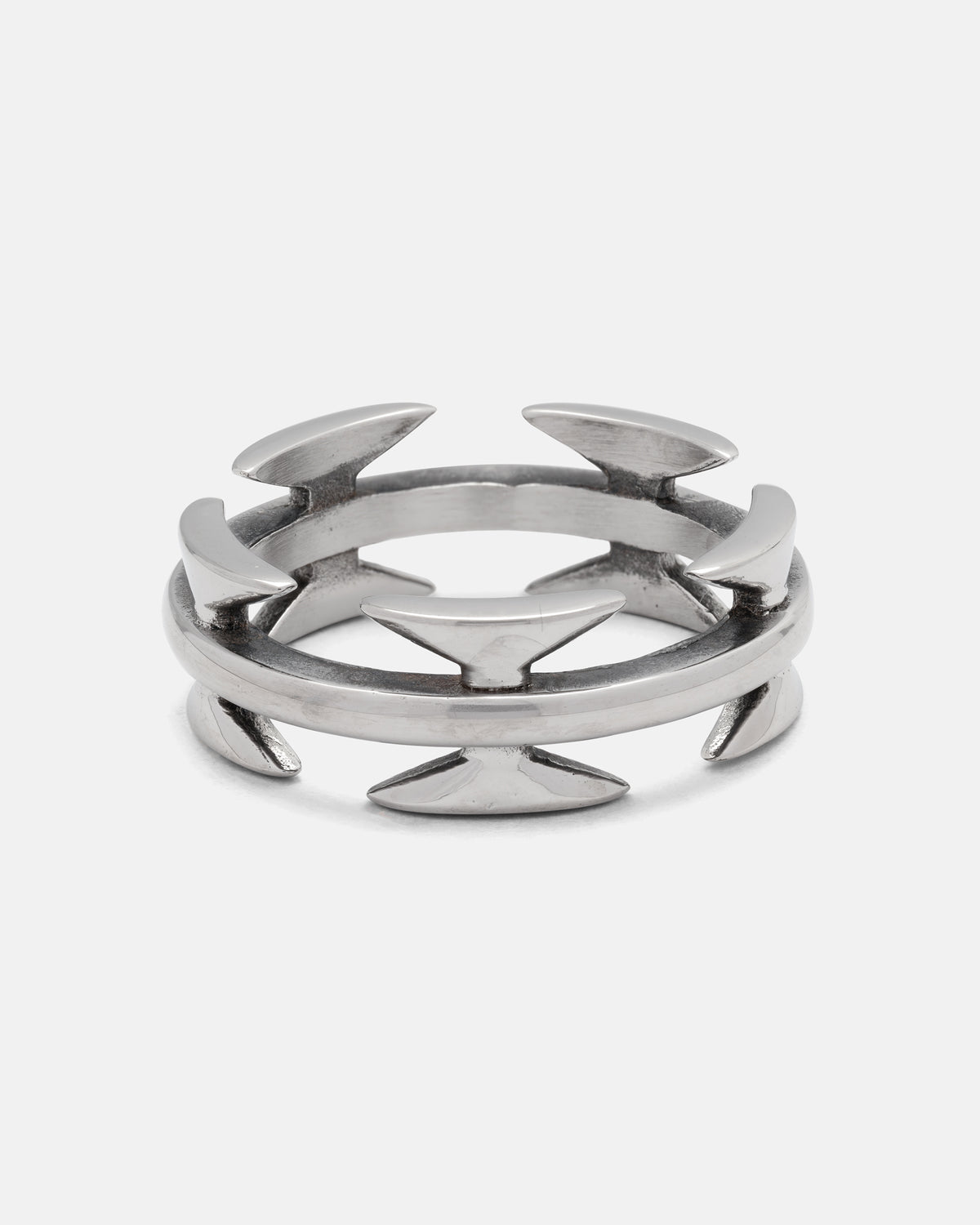 Introducing the Razor Wire Ring by Statement Collective—a silver ring with dual bands adorned with evenly spaced, outward-facing arrowhead shapes, forming a modern geometric design. This razor wire ring offers an edgy accent to any streetwear jewelry collection.