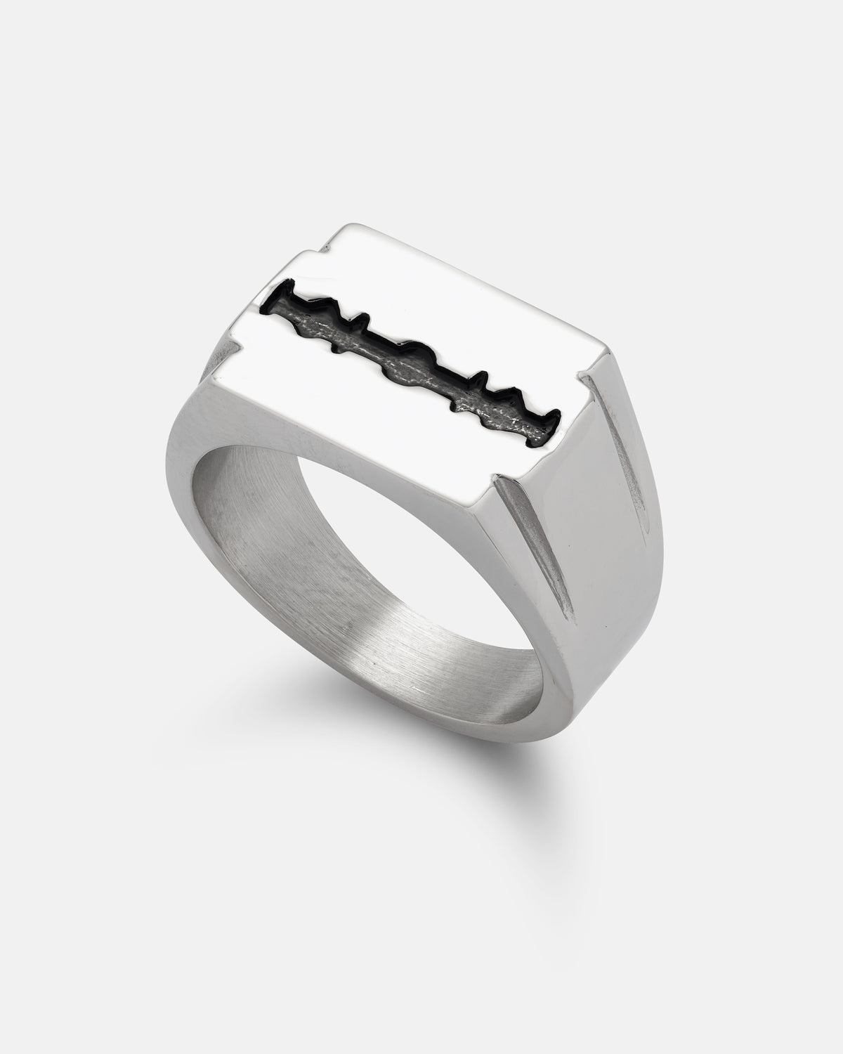 The STATEMENT Razor Blade Signet Ring features a silver band with a rectangular top and an inset black razor blade design at the center, creating a bold piece of punk jewelry, photographed against a plain white background.