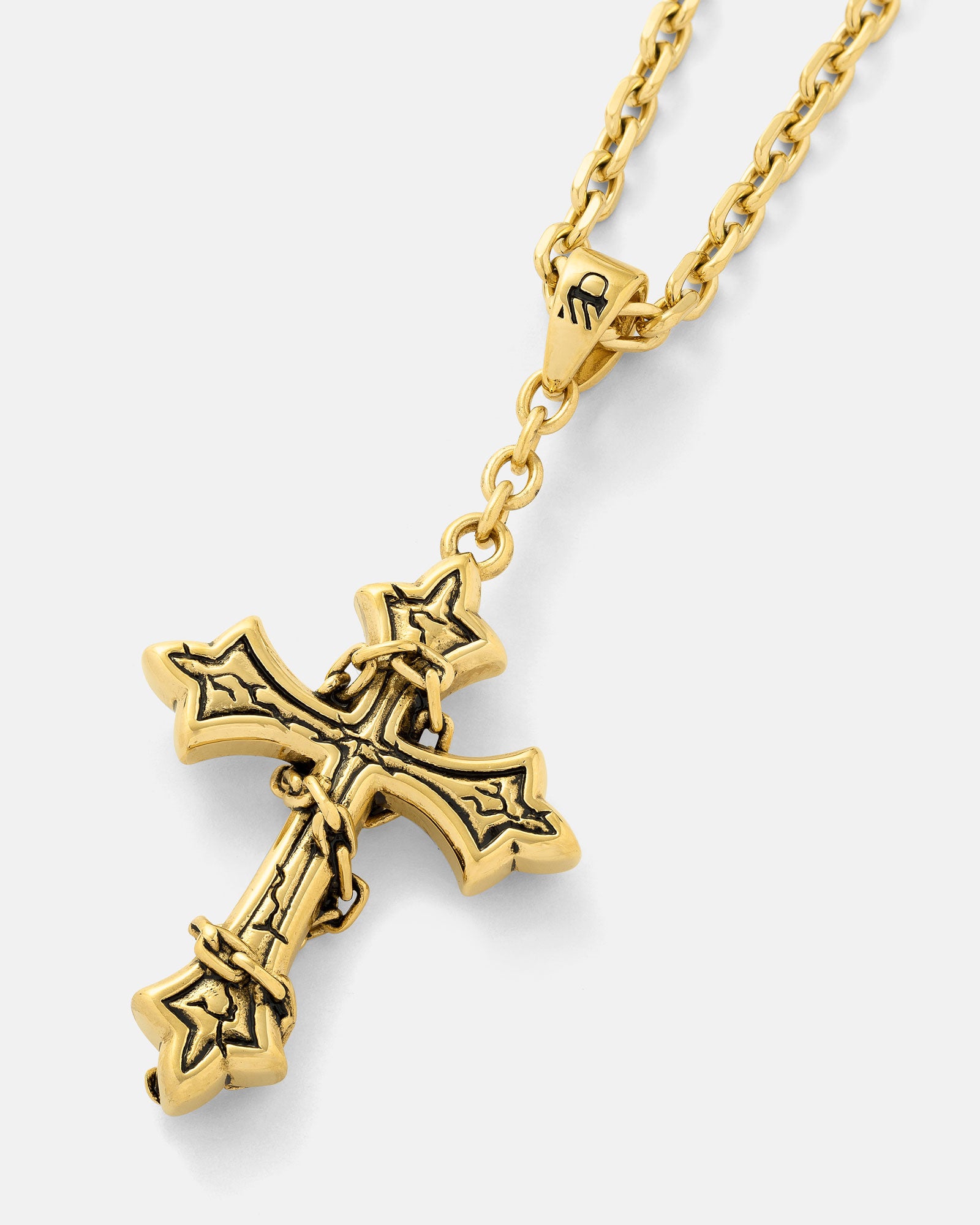 “The Ruins” Pendant (Gold) is an 18k gold plated chain necklace with a gothic cross pendant wrapped in barbed wire, displayed against a plain light backdrop.